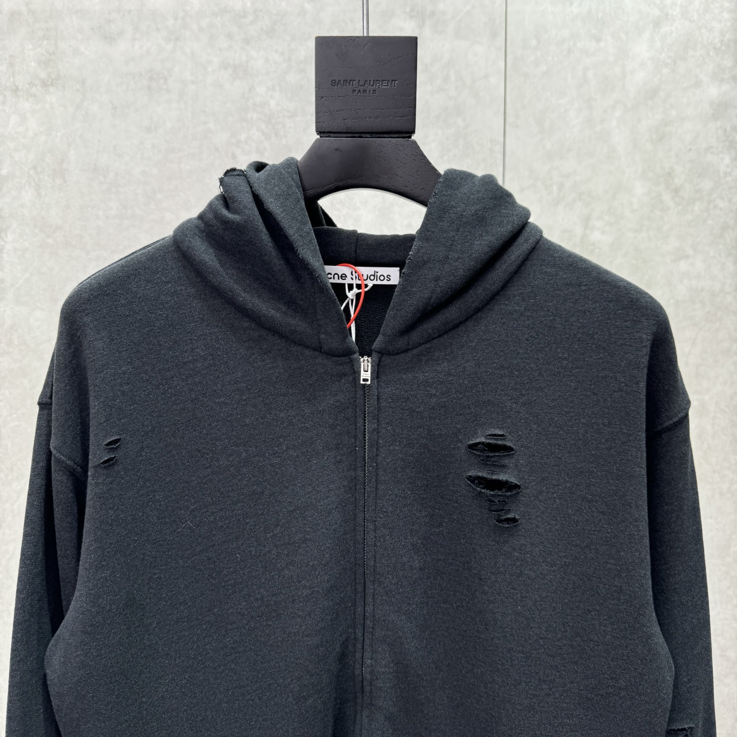 Acne Studios 破洞做旧徽标拉链外套
SIZE S/M/L/XL 💰p325

定制定染1:1墨韵臻柔棉彩棉卫衣料 【面布与毛圈底呈同色配置 （市场面料现货处面底异色 不符合原版） 面料起订量为2吨 单纯面料制造环节耗时45天】云感般的触感 细腻柔软 舒适贴肤 以深邃黛黑为主色调 仿若古老铜器上的斑驳锈迹  前幅同质化clean fit呈现 后幅镌刻着AcneStudios不羁的灵魂 破洞元素的巧妙融入 在黛黑画布上肆意挥洒 是刻意为之的叛逆 是对传统束缚的挣脱 在潮流的浪潮中独树一帜
工艺1:  采用胶浆印花 胸前印花经过三次菲林网板修改 使用胶浆液体涂料在织物上打印图案 烘烤织物以固定印刷图案
工艺2:  衣身多处皆由纯人工规律性定位磨破 手工刷痕 在衣物表面增加纹理和深度感 以模仿自然磨损的质感
工艺3:  面料都经过浇洗 手感质感更佳 不易变形 不易缩水 不易褪色 保持长久的美观
