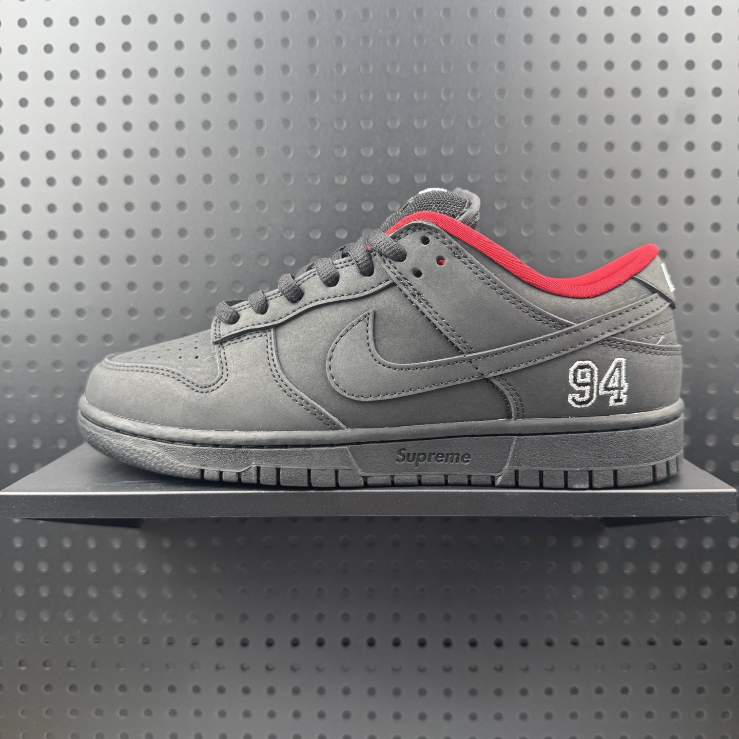 Supreme x Nike Dunk SB Low 黑色 此款鞋跟上绣有“94”字样,纪念品牌的创立年份,该品牌的标志性徽标还被蚀刻在了中底的侧壁上.鞋垫沿用了标准的红色表面,每只鞋垫上都有Nike SB标识,并且Supreme的标识横跨左右两只鞋垫. 货号: HQ8487-001 (01)