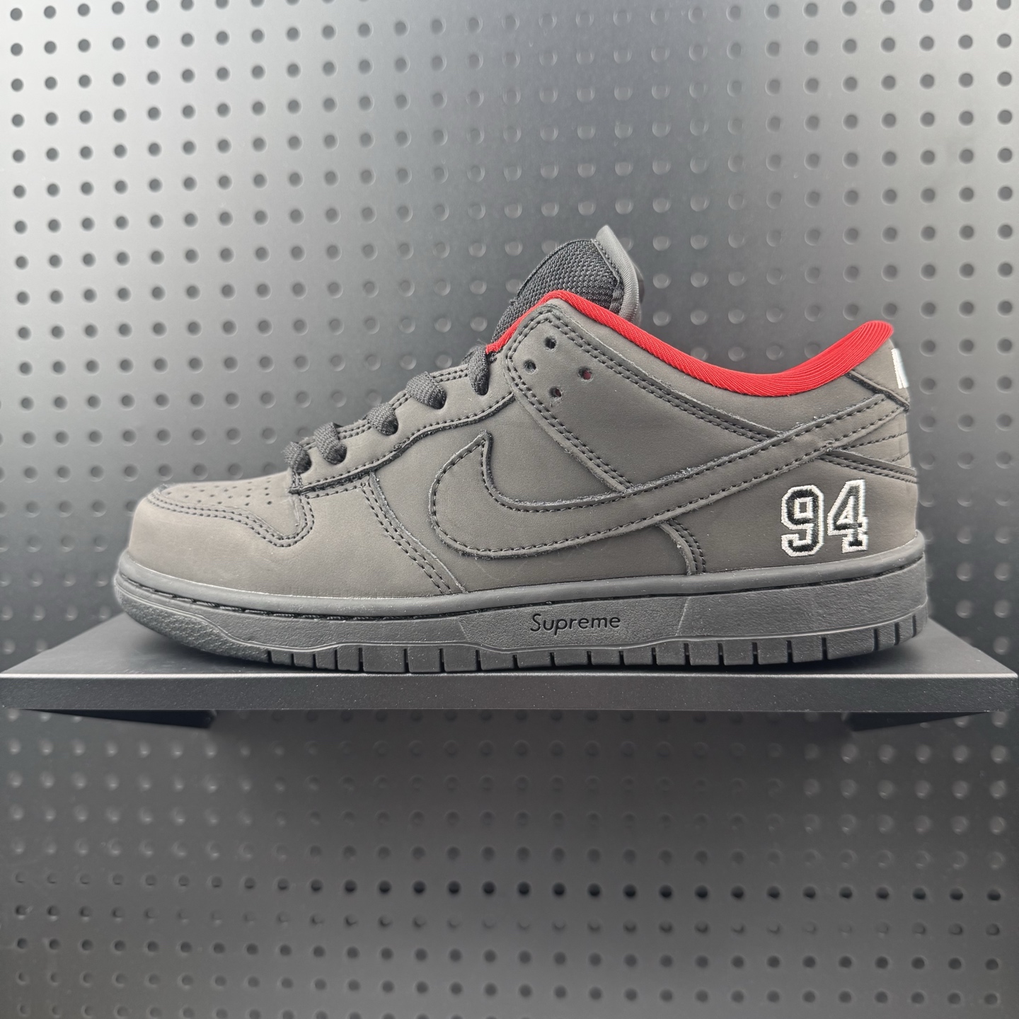 Supreme x Nike Dunk SB Low 黑色 此款鞋跟上绣有“94”字样,纪念品牌的创立年份,该品牌的标志性徽标还被蚀刻在了中底的侧壁上.鞋垫沿用了标准的红色表面,每只鞋垫上都有Nike SB标识,并且Supreme的标识横跨左右两只鞋垫. 货号: HQ8487-001 (24)