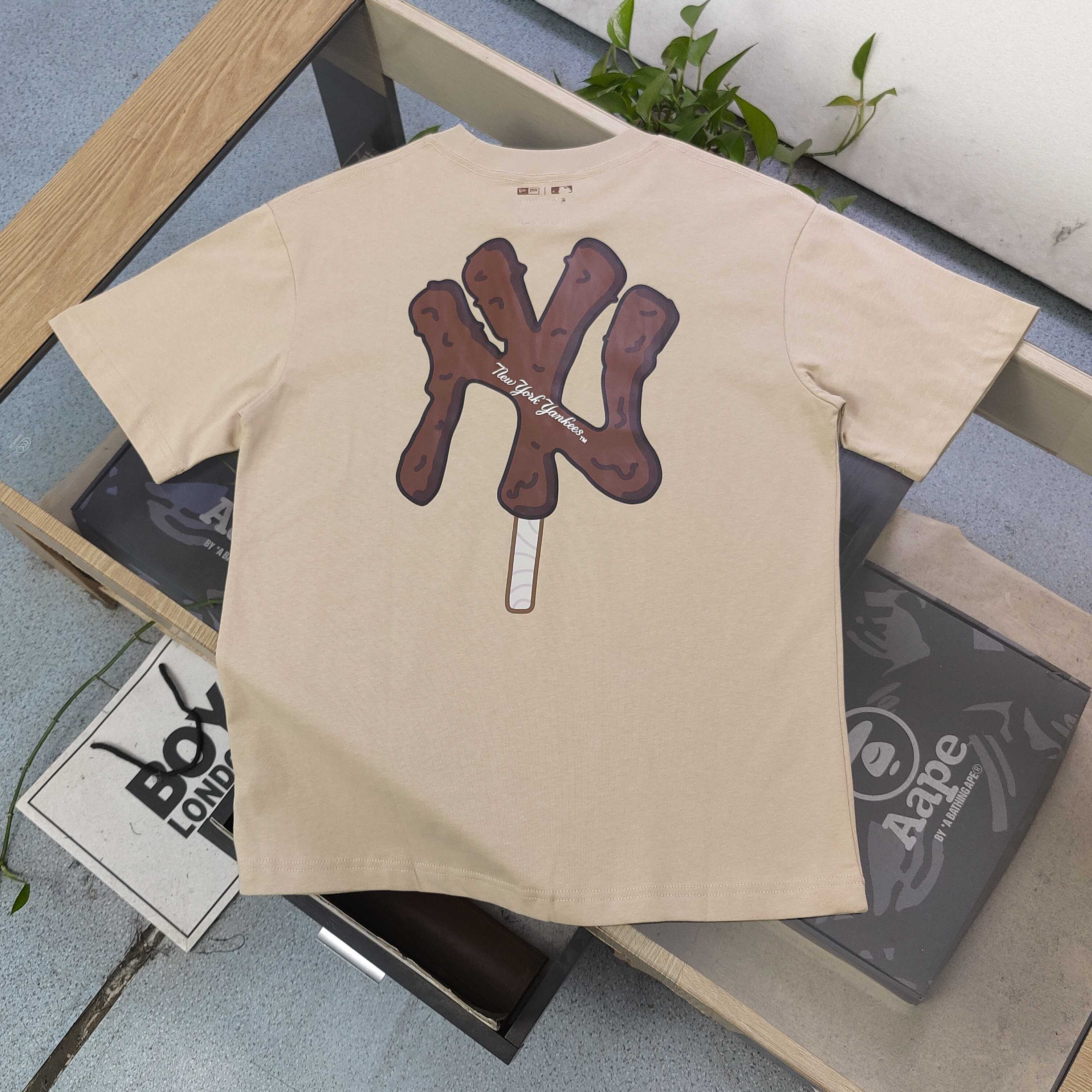 💰75
【款号：CJ207】高版本
2025新款New Era✖️MLB纽亦华联名洋基队NY冰淇淋刺客图案logo印花休闲情侣短袖T恤，刺绣New Era图标logo，选用了260克双纱爽滑棉面料制作而成。精细的做工和清晰的纹路让贴身穿着更加舒适！经典的黑色设计不仅能够有效显瘦，还散发着甜美和酷感的魅力。这款T恤真的非常可爱，整体质地厚实，质量上乘，男女皆可穿着。与男朋友一起穿上，简直超级可爱！我非常喜欢这件T恤，它背后的大片印花设计精致至极，简直是可爱到爆炸！这款T恤的元气减龄效果非常适合情侣装，绝对是夏日必备款式！
颜色：卡其色 粉色
尺码：S～XXL
    衣长 胸围 肩宽 袖长
S    68   100   46.5   22
M   70    104   47.5  22.5
L   72    108   48.5   23
XL  74    112   49.5  23.5
XXL76    116   50.5   24