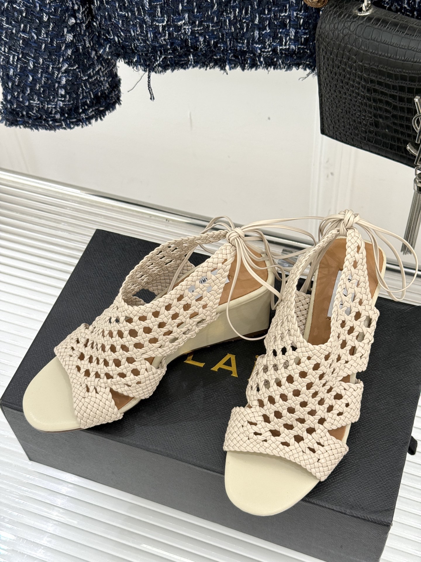 ALAIA|阿莱亚25WF镂空编织坡跟凉鞋
夏日的慵懒与优雅在它身上完美交融。
鞋面是品牌标志性的编织