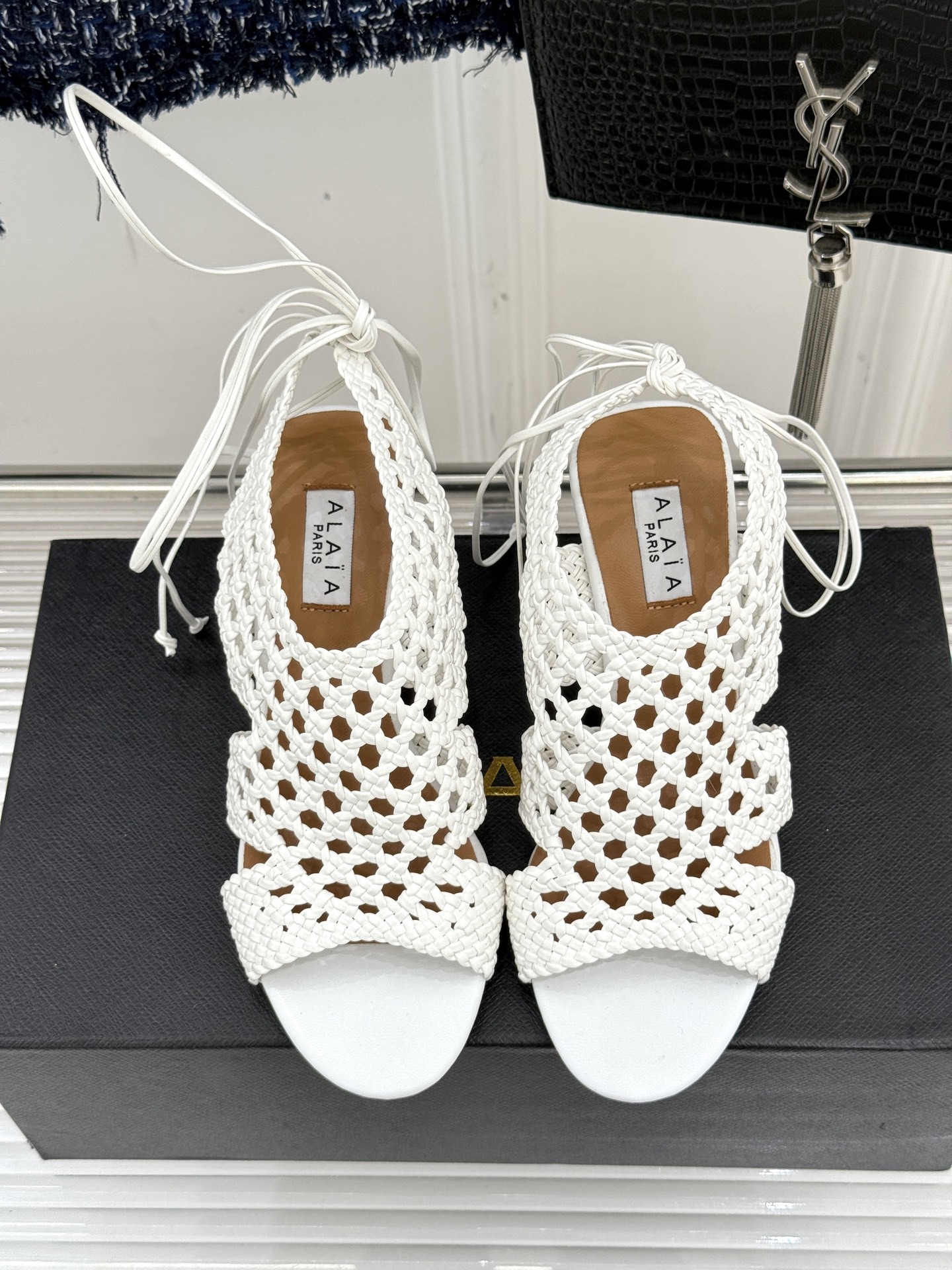 ALAIA|阿莱亚25WF镂空编织坡跟凉鞋
夏日的慵懒与优雅在它身上完美交融。
鞋面是品牌标志性的编织
