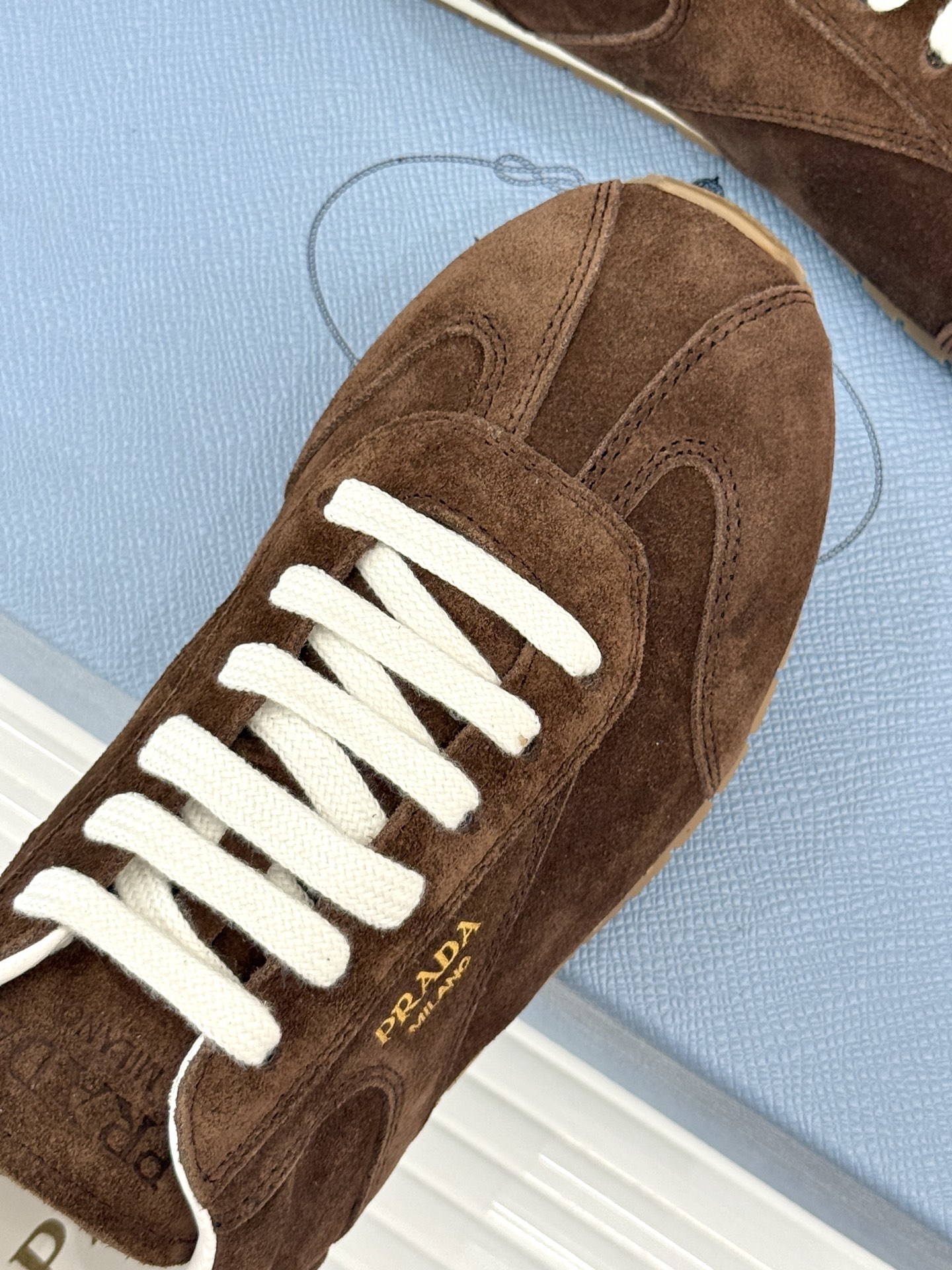 Prada/普拉达25WF新品复古休闲德训鞋标志性的小字母低调地镶嵌于鞋身侧面金属质感的标识在光线下闪烁