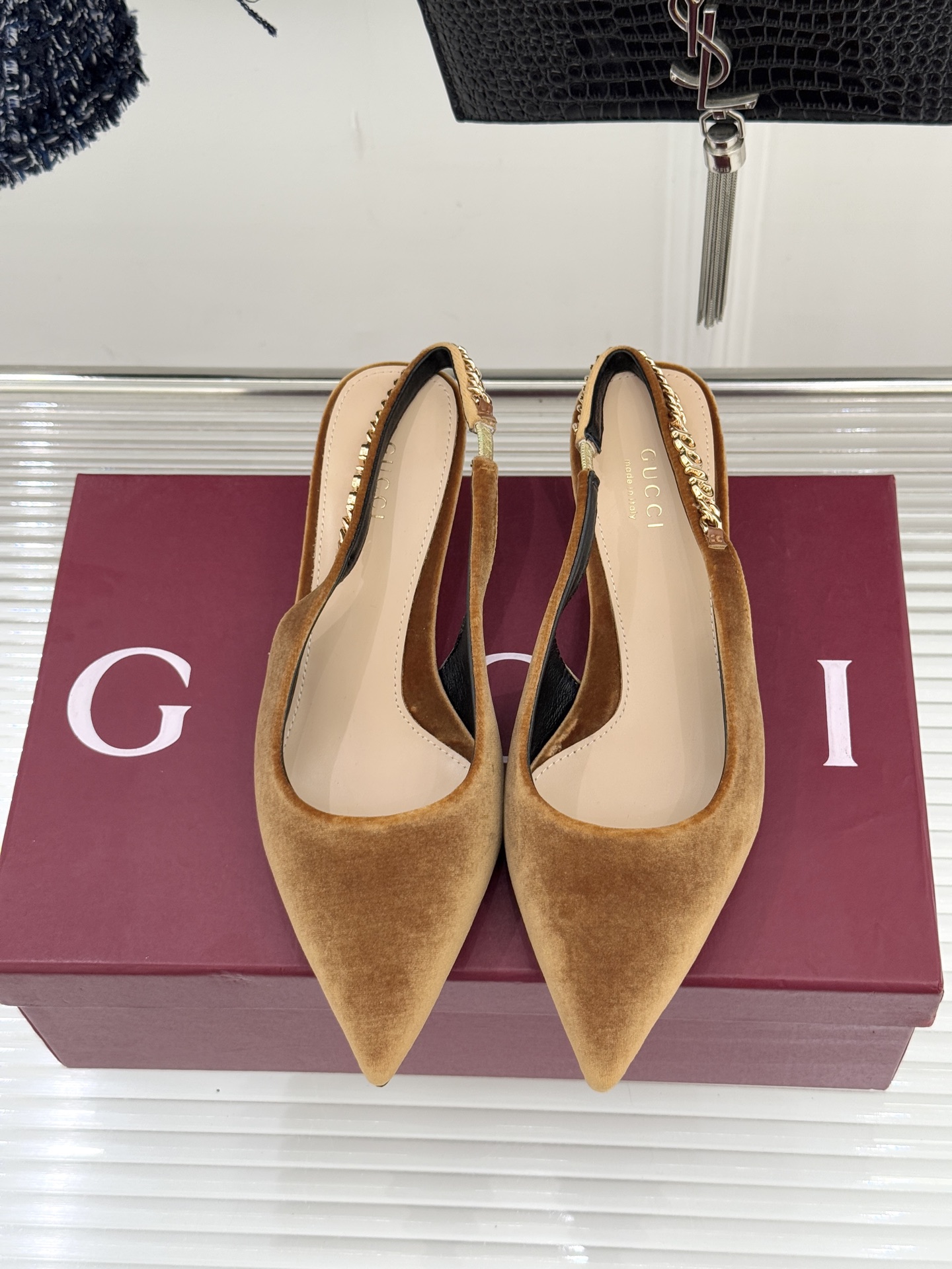 Gucci/古驰经典尖头后绕带金属链条丝绒后空高跟凉鞋以丝绒肌理碰撞品牌基因演绎意式奢华浪漫。随光影流动