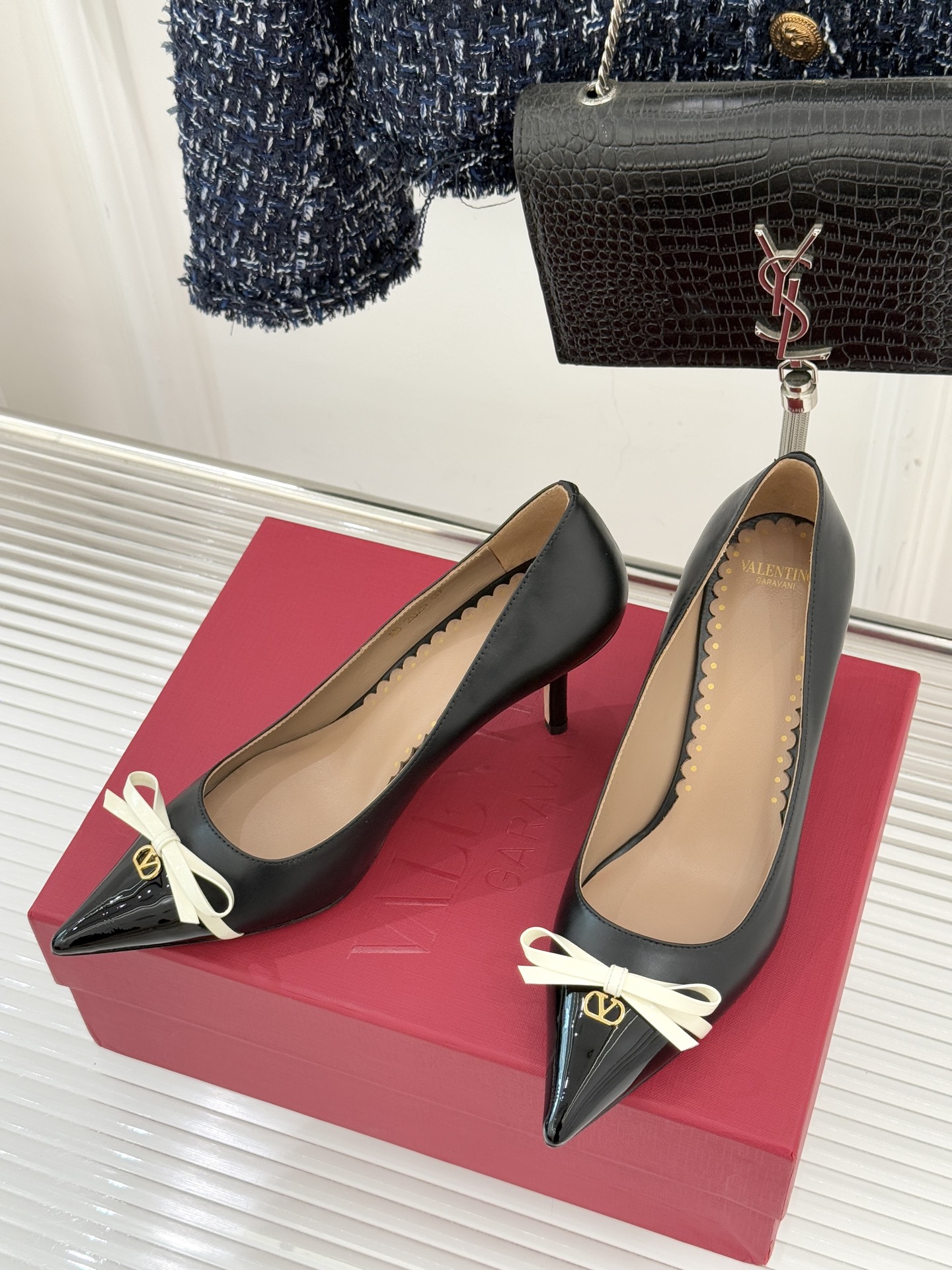 Valentino/华伦天奴经典尖头蝴蝶结高跟鞋以标志性小V扣镌刻意式奢雅将利落锋芒与温柔浪漫完美平衡。