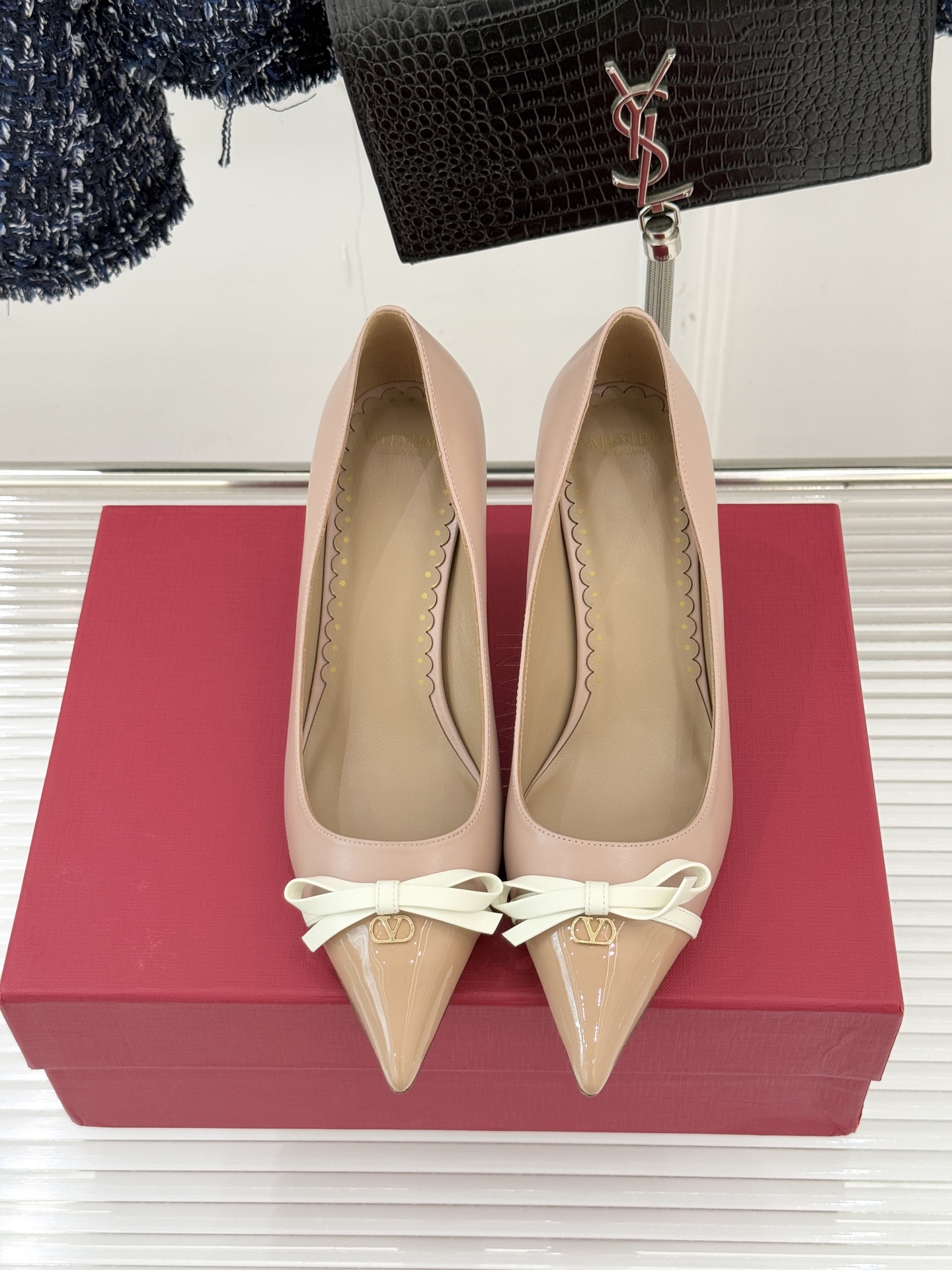 Valentino/华伦天奴经典尖头蝴蝶结高跟鞋以标志性小V扣镌刻意式奢雅将利落锋芒与温柔浪漫完美平衡。