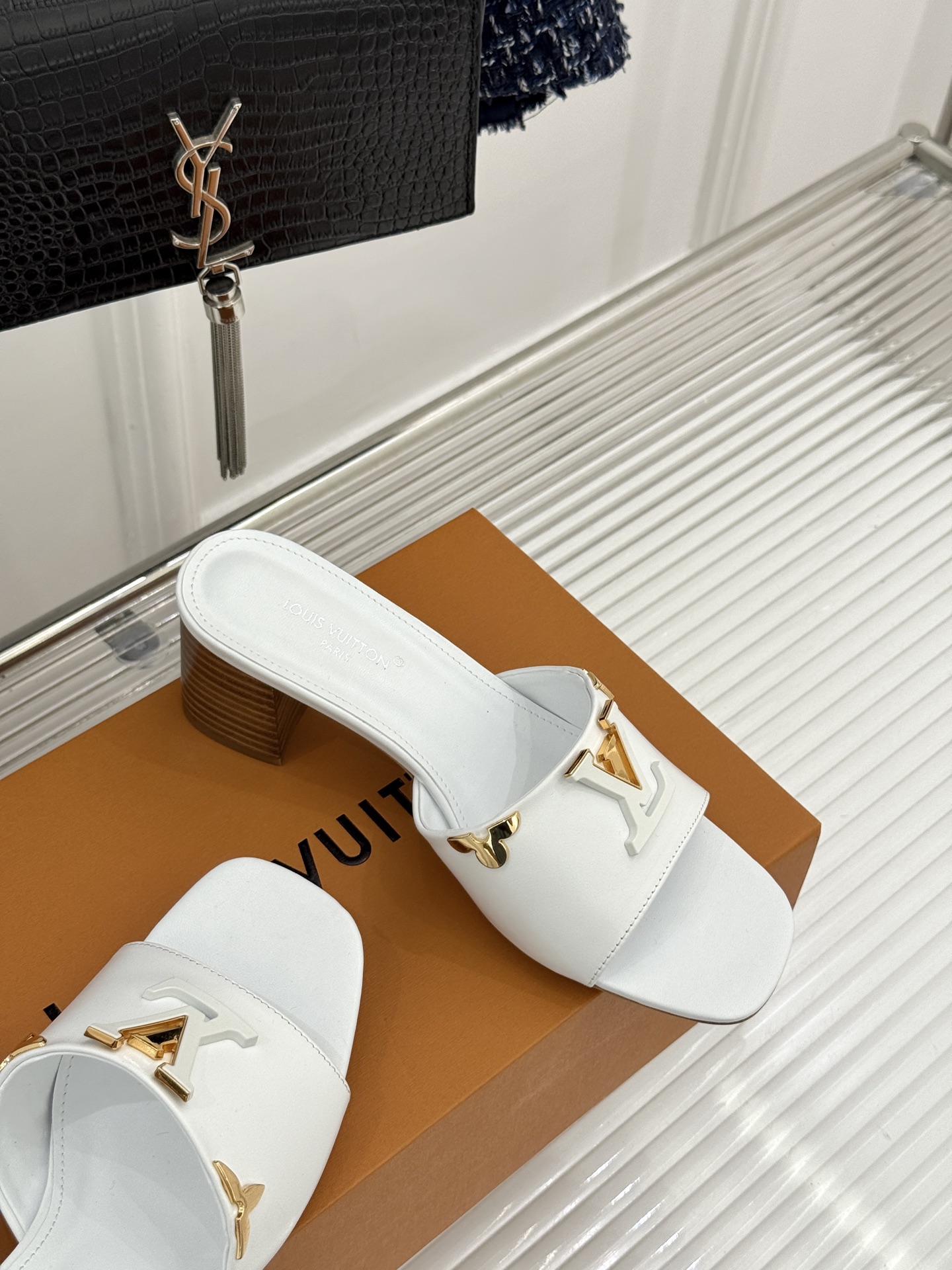 L*V驴牌经典爆款粗跟拖鞋它的设计简约而不失格调LV标识以金属质感的扣饰形式点缀仿佛将整个品牌的格调与品