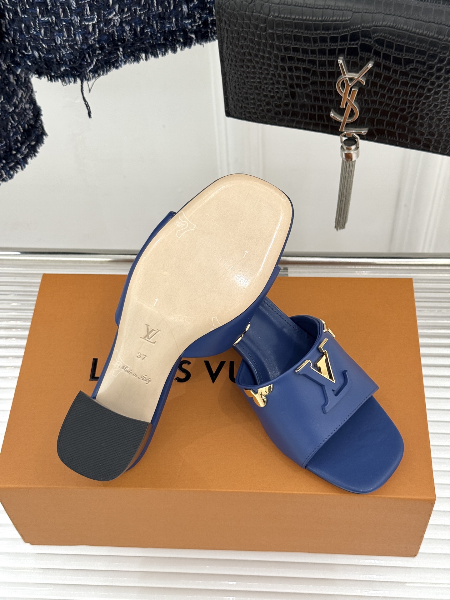 L*V驴牌经典爆款粗跟拖鞋它的设计简约而不失格调LV标识以金属质感的扣饰形式点缀仿佛将整个品牌的格调与品