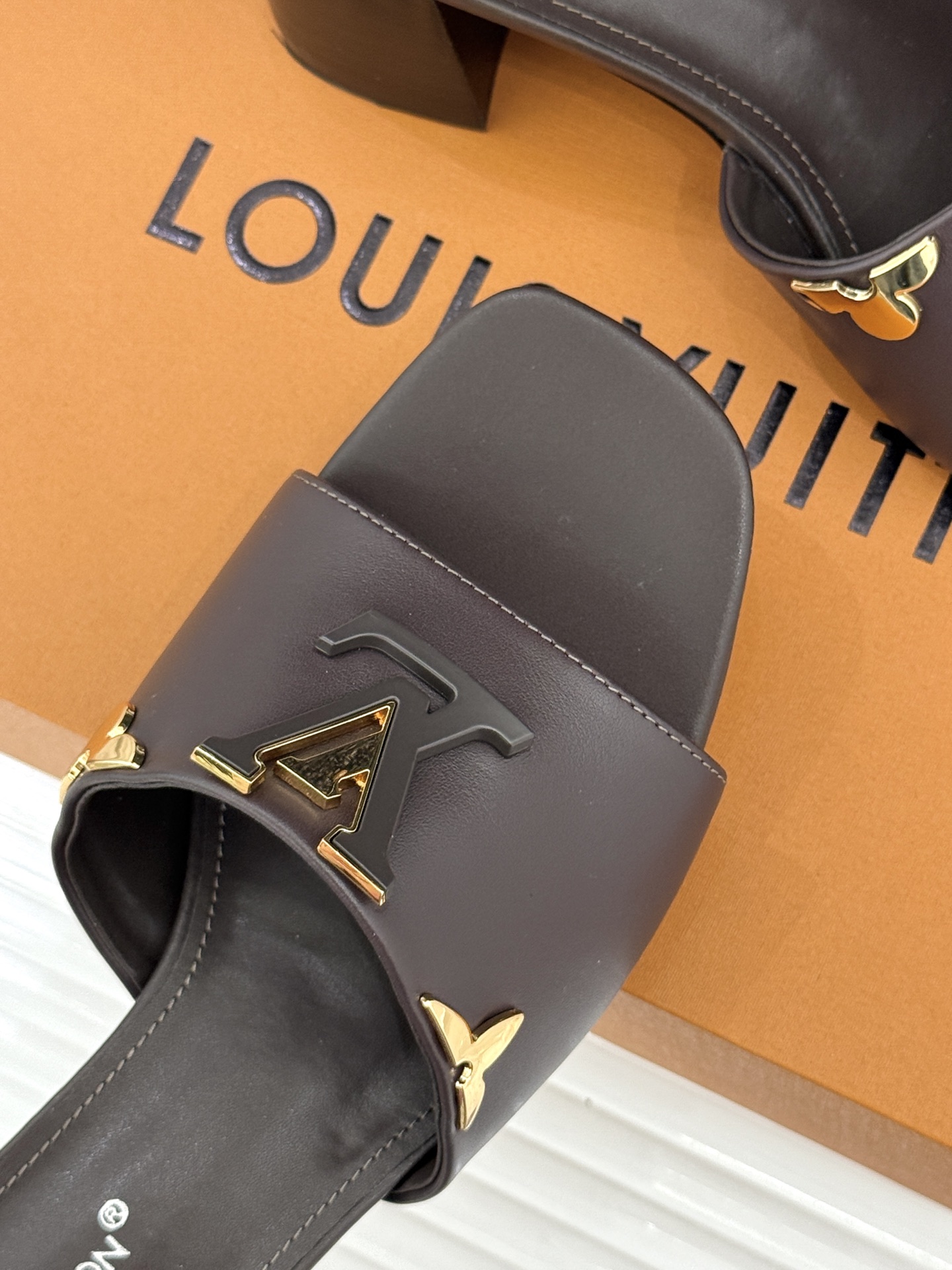 L*V驴牌经典爆款粗跟拖鞋它的设计简约而不失格调LV标识以金属质感的扣饰形式点缀仿佛将整个品牌的格调与品