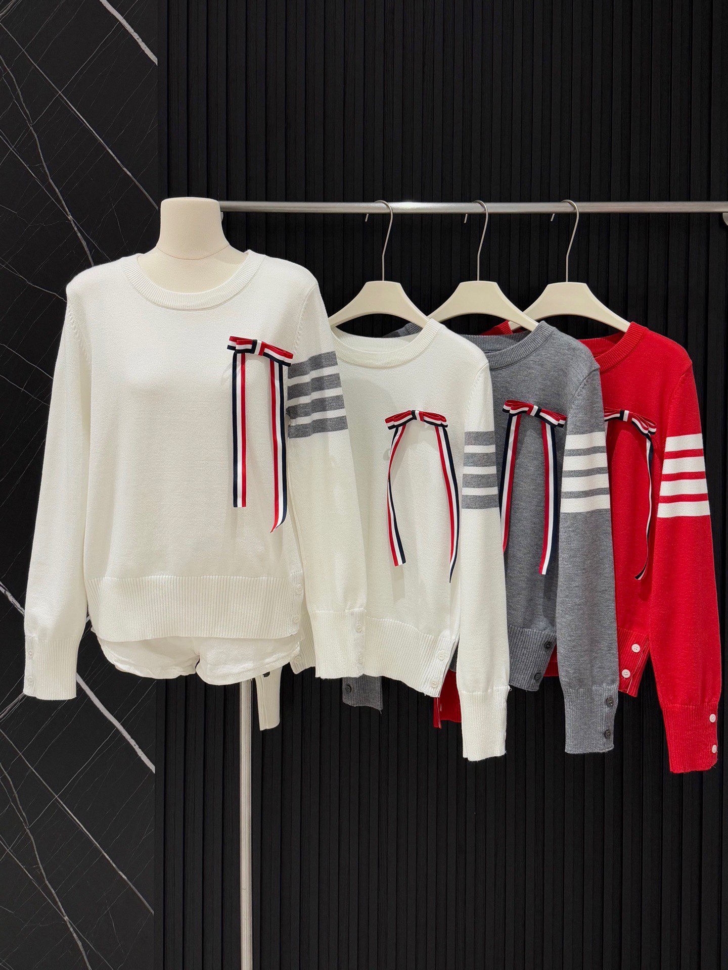  💰105
TB💙学院风可拆卸蝴蝶结毛衣​​✨
这款tb风卡其色针织毛衣，学院风满满！袖子上四条杠+可拆卸蝴蝶结，细节感拉满🎀。针织材质柔软舒适，春秋冬穿超合适。纽扣装饰让层次感更丰富，搭配百褶裙或高腰裤，轻松get优雅知性风👗。质感在线，通勤休闲都能穿！
📍均码衣长53胸围86
颜色：灰色 红色 白色