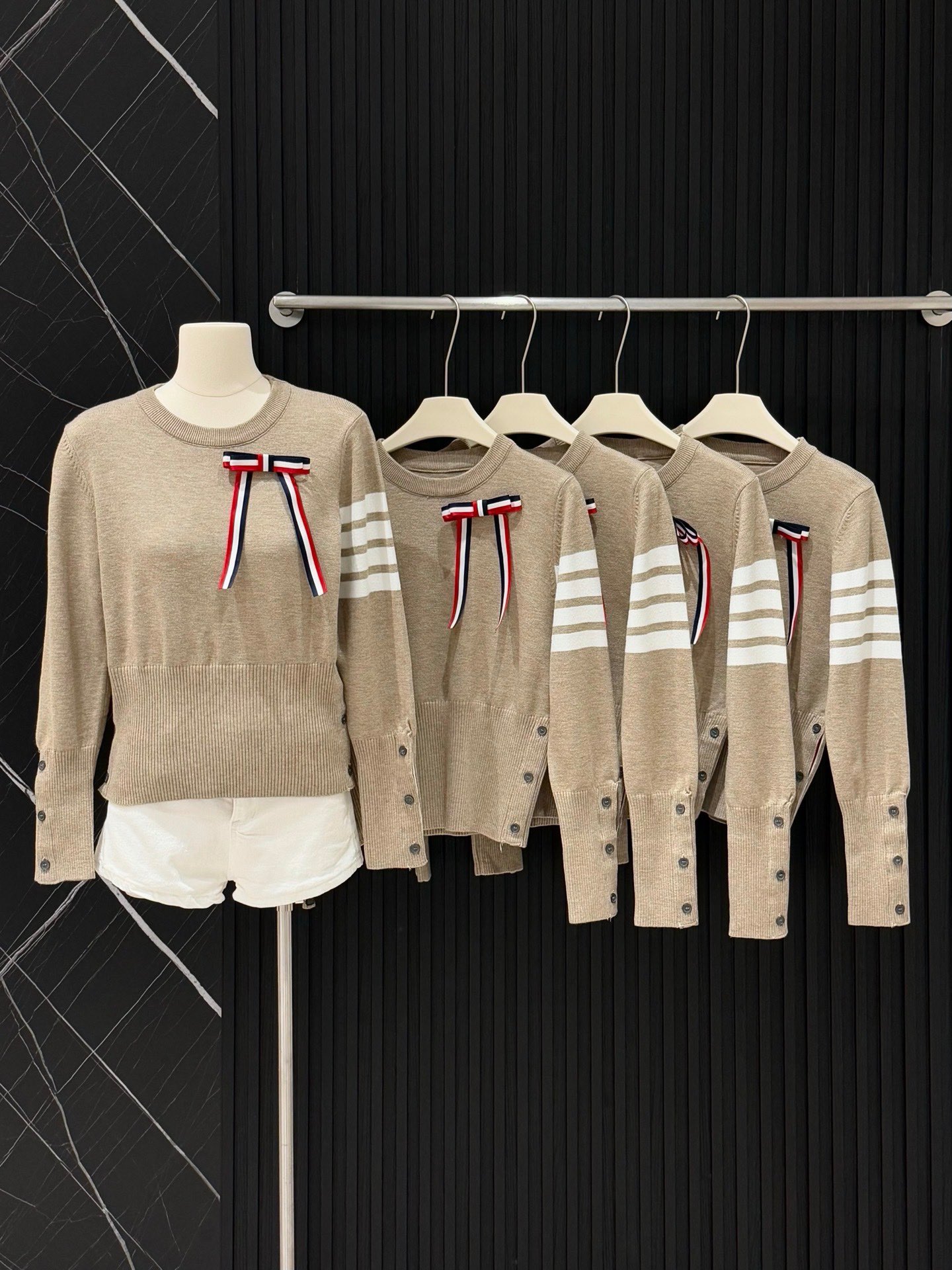  💰105
TB💙学院风可拆卸蝴蝶结毛衣​​✨
这款tb风卡其色针织毛衣，学院风满满！袖子上四条杠+可拆卸蝴蝶结，细节感拉满🎀。针织材质柔软舒适，春秋冬穿超合适。纽扣装饰让层次感更丰富，搭配百褶裙或高腰裤，轻松get优雅知性风👗。质感在线，通勤休闲都能穿！
📍均码衣长53胸围86
颜色：卡其