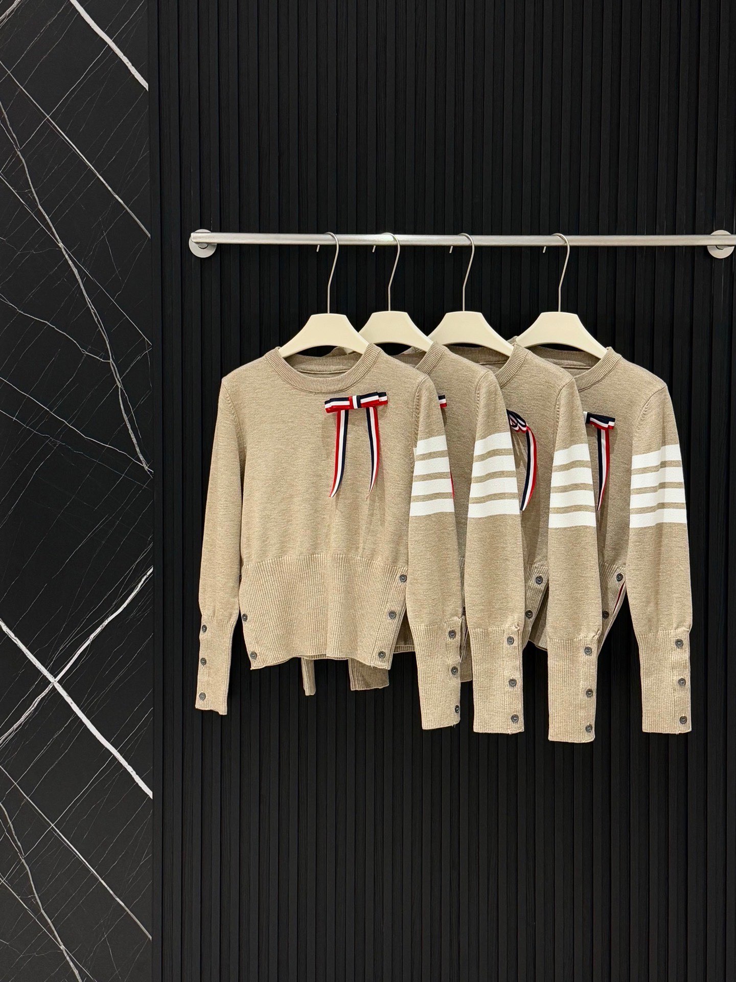  💰105
TB💙学院风可拆卸蝴蝶结毛衣​​✨
这款tb风卡其色针织毛衣，学院风满满！袖子上四条杠+可拆卸蝴蝶结，细节感拉满🎀。针织材质柔软舒适，春秋冬穿超合适。纽扣装饰让层次感更丰富，搭配百褶裙或高腰裤，轻松get优雅知性风👗。质感在线，通勤休闲都能穿！
📍均码衣长53胸围86
颜色：卡其