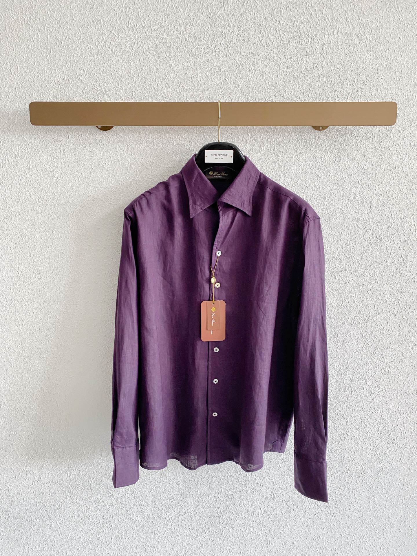 NO:936095,Loro Piana three-color pure linen quiet luxury long-sleeved shirt fabric uses high-grade imported natural linen raw materials, which are softened and pre-processed to polish away the native burrs, greatly improving the shortcomings of ordinary linen skin. The fabric has a clear and delicate natural fiber texture, showing a low-key matte texture without exaggerated shine; the fiber has dense breathable pores, which has excellent performance in wicking away sweat and heat in spring and summer. It is not easy to sweat and stick to the body when worn in high temperature environments.  The natural wrinkles formed by daily wear are the unique characteristics of the fabric, which further enhances the relaxed Italian style. The color fastness of the fabric is excellent, and the three dark colors are not easy to whiten and fade after being worn for a long time. The style and details are made of the highly recognizable Italian windsor collar with a large open angle. The collar has a built-in shaping lining, which is not easy to collapse after repeated washing and care. Once buttoned, it is formal and elegant, and the first button can be unbuttoned to create a casual and relaxed shape, with a wider adaptability span.  The style adopts a slightly loose front-shoulder cut, which is very tolerant for body shapes with slippery shoulders, wider shoulders, and excess fat on the waist and abdomen, and allows the upper body to move freely without restraint. The placket is decorated with exquisite small buttons as a detail highlight, and the wiring is fine and hidden. There is no exposed exaggerated brand logo on the whole, and the sense of luxury is restrained; the standard long-sleeved cuffs can be freely folded to change styles, and the arc hem can be worn either tucked into the waistband or outside, suitable for a variety of matching ideas. Color selection  The original hemp and beige color is a basic and versatile model with soft and simple tones, suitable for various daily scenes of commuting and travel. It is suitable for most color bottoms and has the highest fault tolerance rate for daily wear; the retro purple tone is a niche color combination that breaks away from the monotony of conventional solid colors and is highly recognizable. It is suitable for light gatherings and high-quality daily travel. It has an outstanding effect when paired with black and dark gray bottoms;  The retro and calm dark brown color is suitable for the transition between autumn and winter as well as more mature business and casual wear. The color is calm and textured, and it is very suitable for suit layering styles. Size M-4XL,,loro piana,shirts,business suit,19860909Loro Piana三色纯亚麻静奢长袖衬衫 面料 甄选高品级进口天然亚麻原料,经过柔化预处理打磨掉原生毛刺,大幅改善普通亚麻扎肤的短板. 面料具备清晰细腻的天然纤维肌理,呈现低调哑光质感,没有浮夸亮泽； 纤维自带密集透气孔隙,春夏时节排汗、散热表现出众,高温环境穿着不易闷汗粘身. 日常穿搭形成的自然褶皱是面料独有特质,进一步烘托意式松弛格调,面料色牢度优异,三款深色调久穿不易泛白褪色. 版型与细节 采用辨识度出色的意式大开角温莎领,领口内置定型衬片,多次洗护也不易塌卷. 扣合之后正式得体,解开首颗纽扣能够打造随性松弛的造型,适配跨度更广. 版型采用微宽松正肩剪裁,对溜肩、肩宽偏大、腰腹有富余赘肉的身形包容度优秀,上身活动自在无束缚. 门襟点缀精致小扣作为细节亮点,走线细密隐蔽,整体没有外露的夸张品牌标识,高级感内敛克制； 标准长袖袖口可自由翻折变换风格,圆弧下摆兼顾塞裤腰、外放两种穿搭形式,适配多样搭配思路. 配色选择 原生麻米色基础百搭款,色调柔和质朴,适配通勤、出游各类日常场景,适配绝大多数色系的下装,日常穿搭容错率最高； 复古紫调氛围感小众配色,摆脱常规纯色的单调感,穿搭辨识度突出,适配轻聚会、质感日常出行,搭配黑、深灰下装效果出众； 深棕咖色复古沉稳色调,适配秋冬过渡以及偏成熟的商务休闲穿搭,色调沉稳显质感,很适配西装叠穿造型. 码数M-4XL,,loro piana,shirts,business suit,,Men's clothing