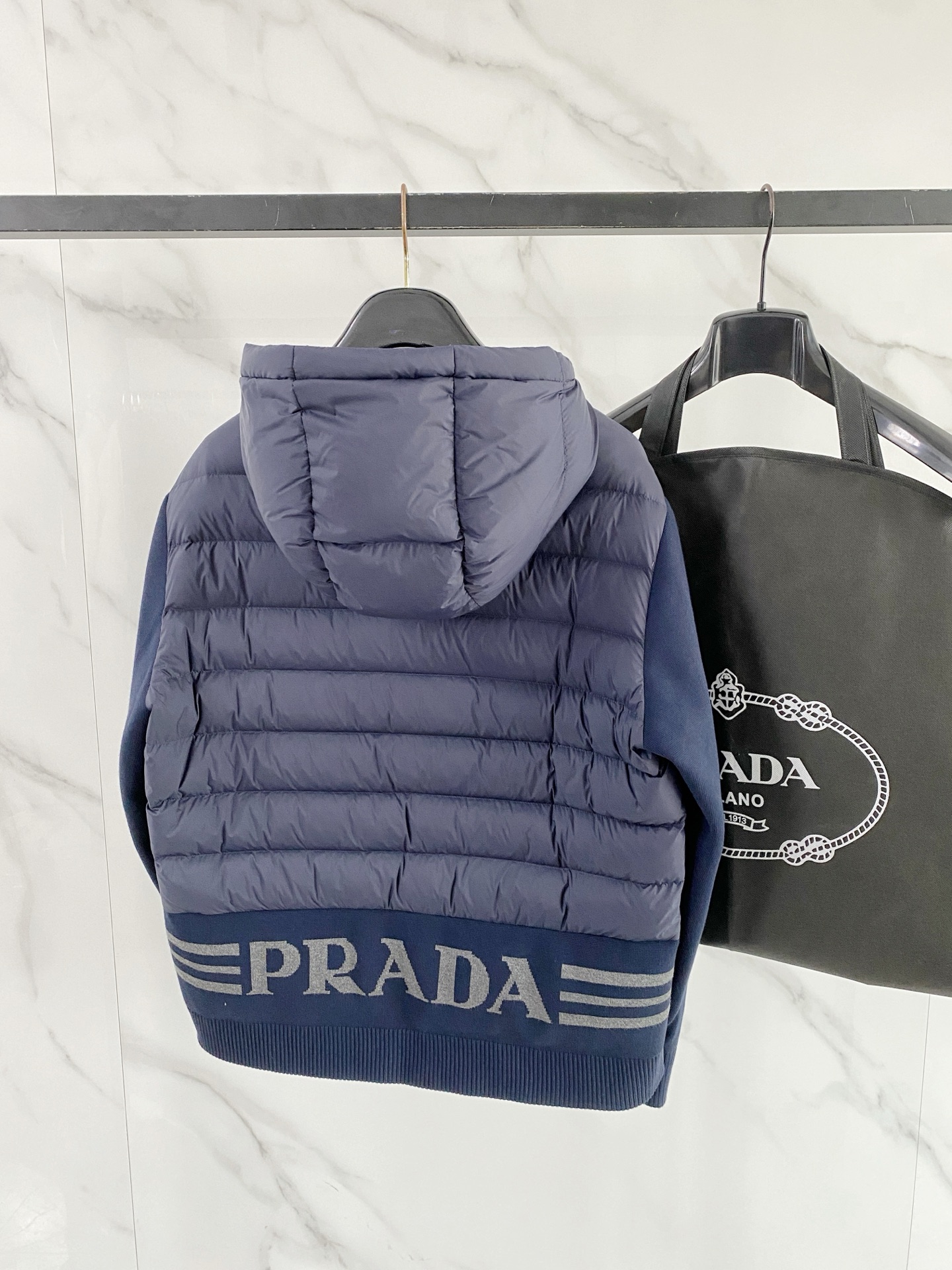 Prada 普拉达 2026秋冬新款拼接连帽轻薄羽绒服 前片竖条充棉分区锁温,侧边搭配弹力针织袖,上身完全不臃肿 胸口经 Prada 普拉达 2026秋冬新款拼接连帽轻薄羽绒服 前片竖条充棉分区锁温,侧边搭配弹力针织袖,上身完全不臃肿 胸口经