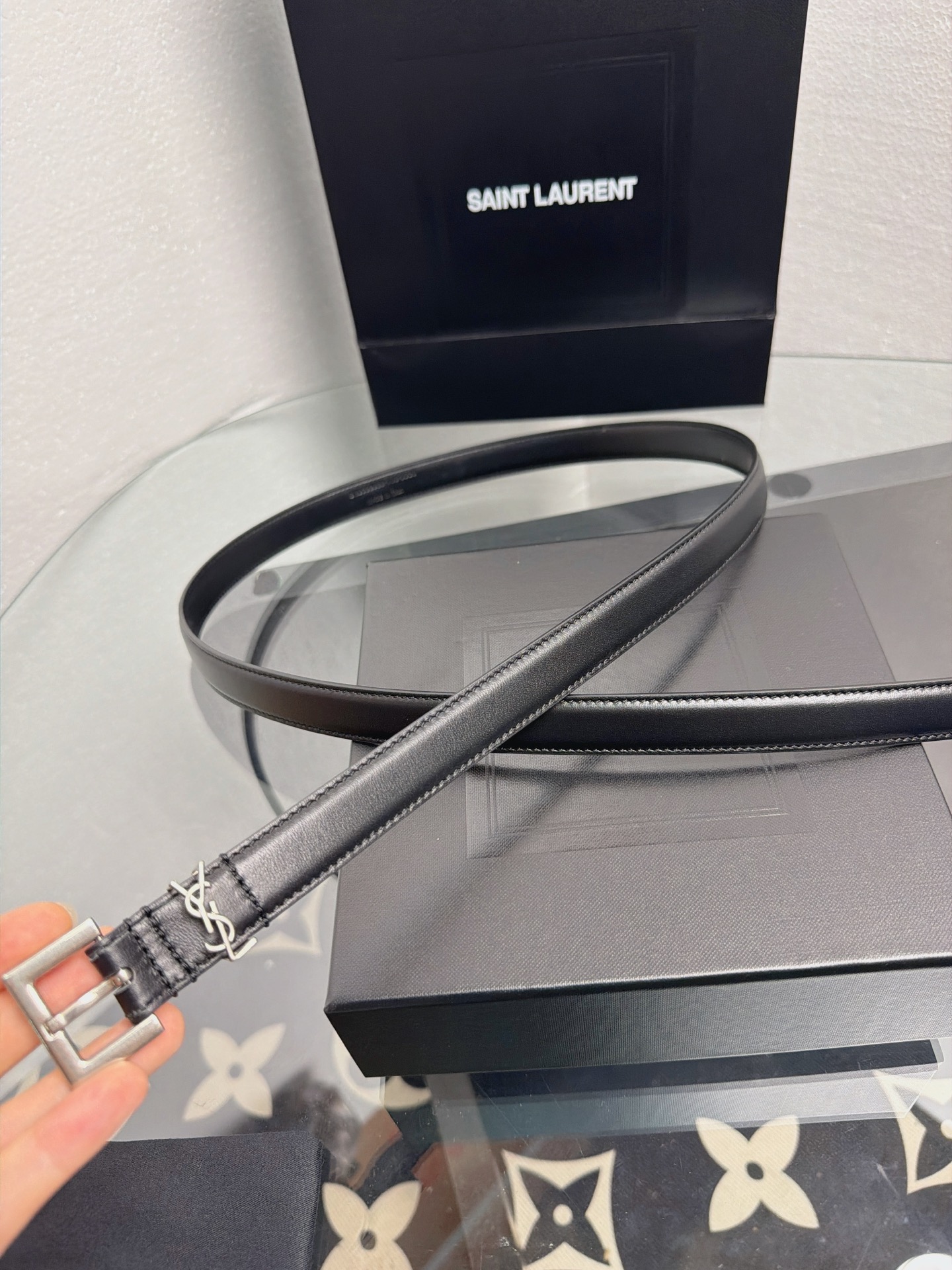 YSL 黑色细款光面牛皮银扣腰带，品牌标志性logo搭配利落方扣，窄版设计简约精致，适配裙装、裤装多种造