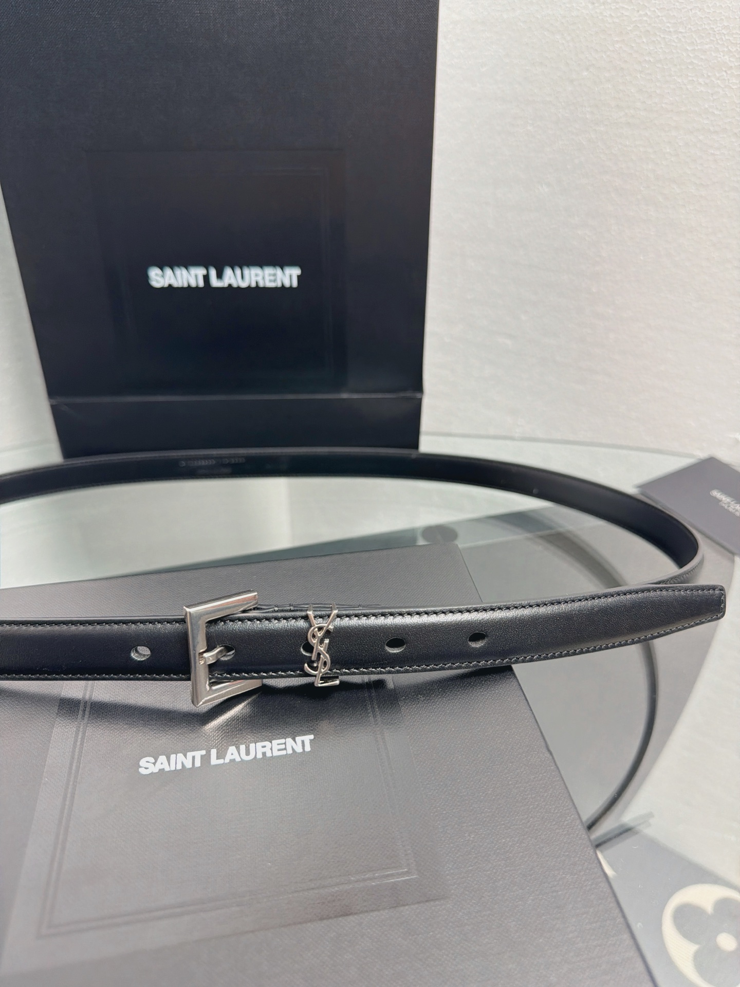 YSL 黑色细款光面牛皮银扣腰带，品牌标志性logo搭配利落方扣，窄版设计简约精致，适配裙装、裤装多种造