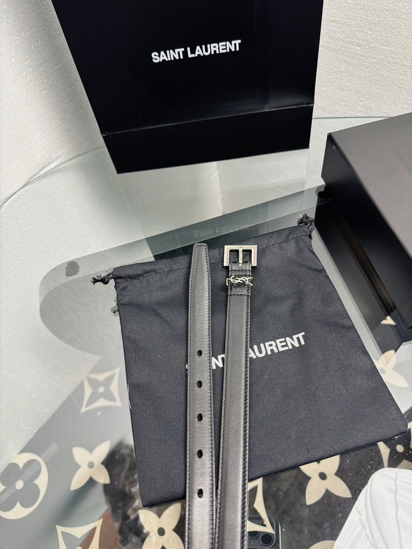 YSL 黑色细款光面牛皮银扣腰带，品牌标志性logo搭配利落方扣，窄版设计简约精致，适配裙装、裤装多种造