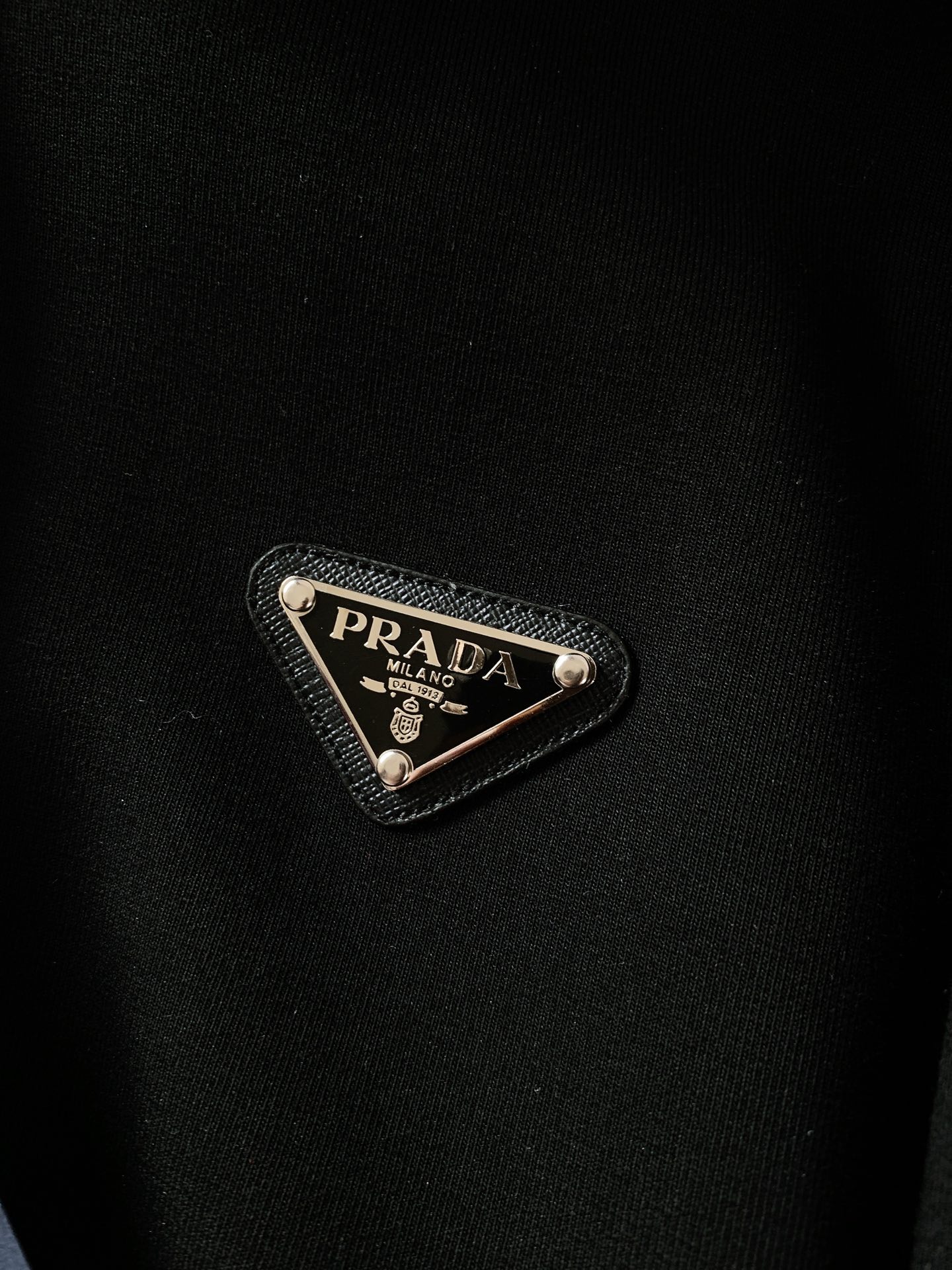 
Prada 普拉达 空气棉珐琅金属三角标拉链连帽外套，这款针梭织拼接从现代视角重新诠释 P家元素。定织