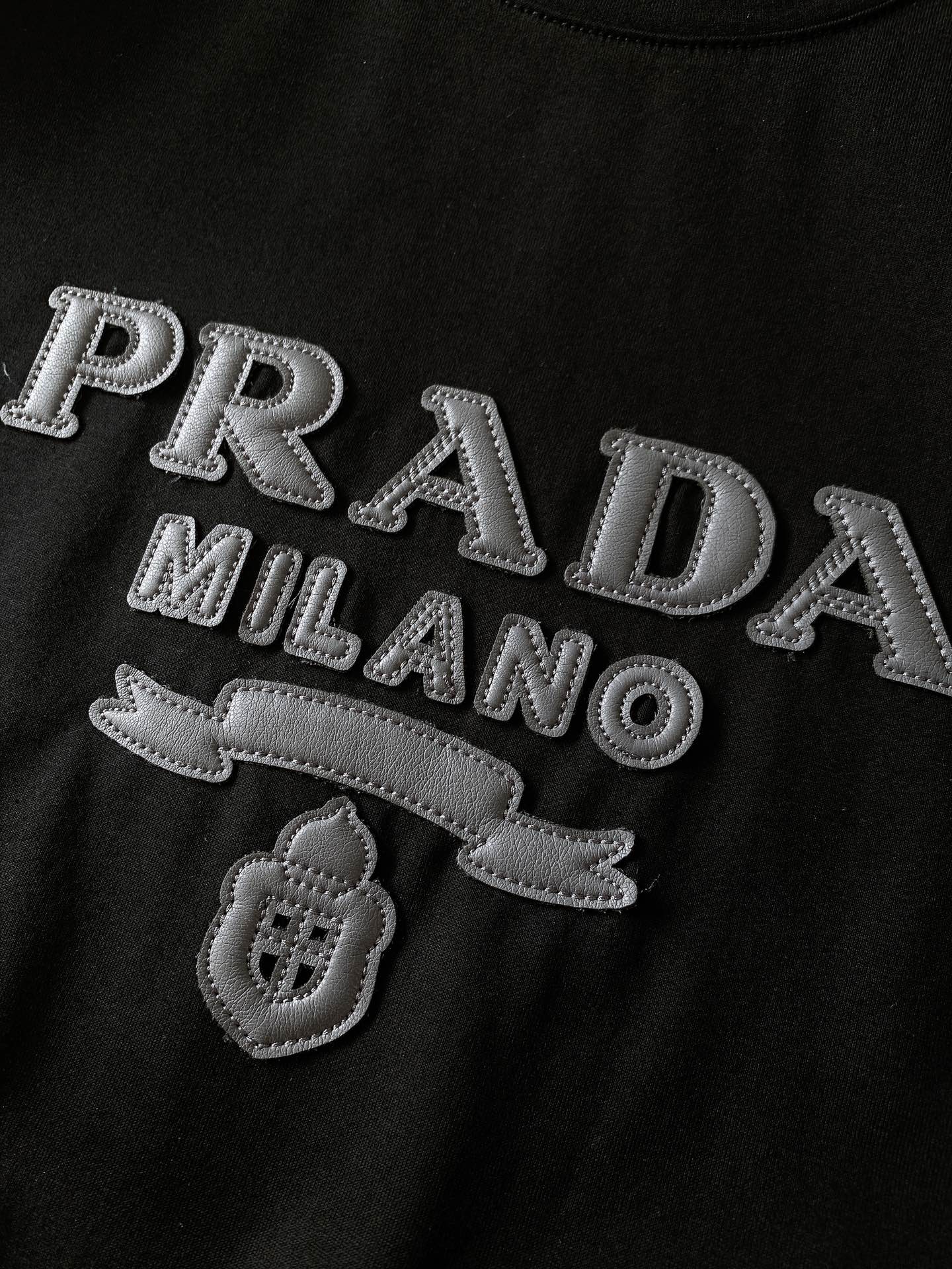 
Prada 普拉达 2025SS春夏新品 
拼皮标识T恤，经典标志图案logo设计，吸引而有亮点，细看