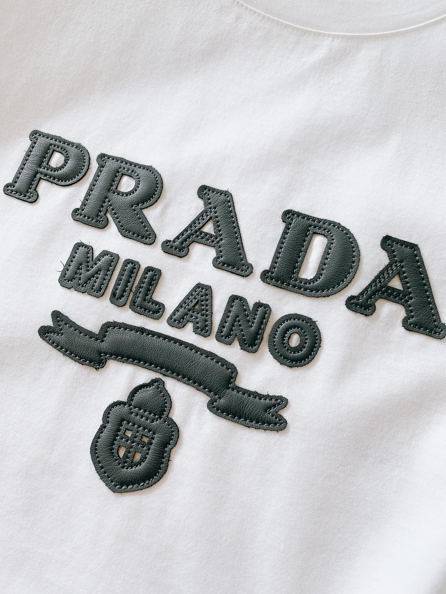 
Prada 普拉达 2025SS春夏新品 
拼皮标识T恤，经典标志图案logo设计，吸引而有亮点，细看