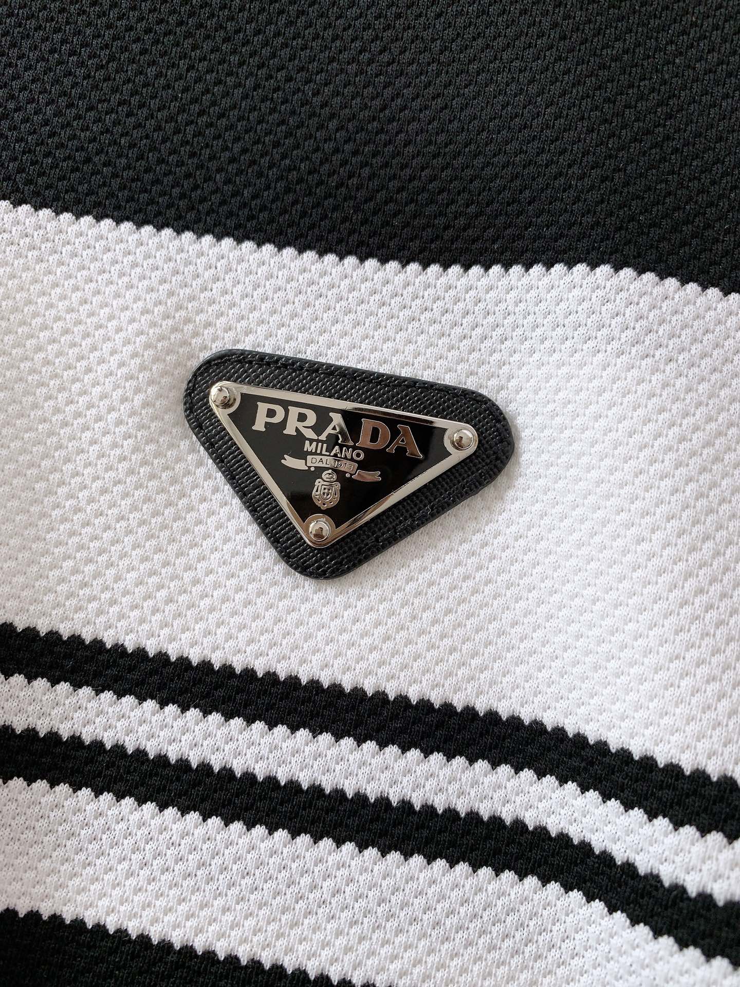 
Prada 普拉达 2025SS春夏新品 
撞色翻领T恤，甄选优质透气面料。胸前经典三角标五金装饰搭配