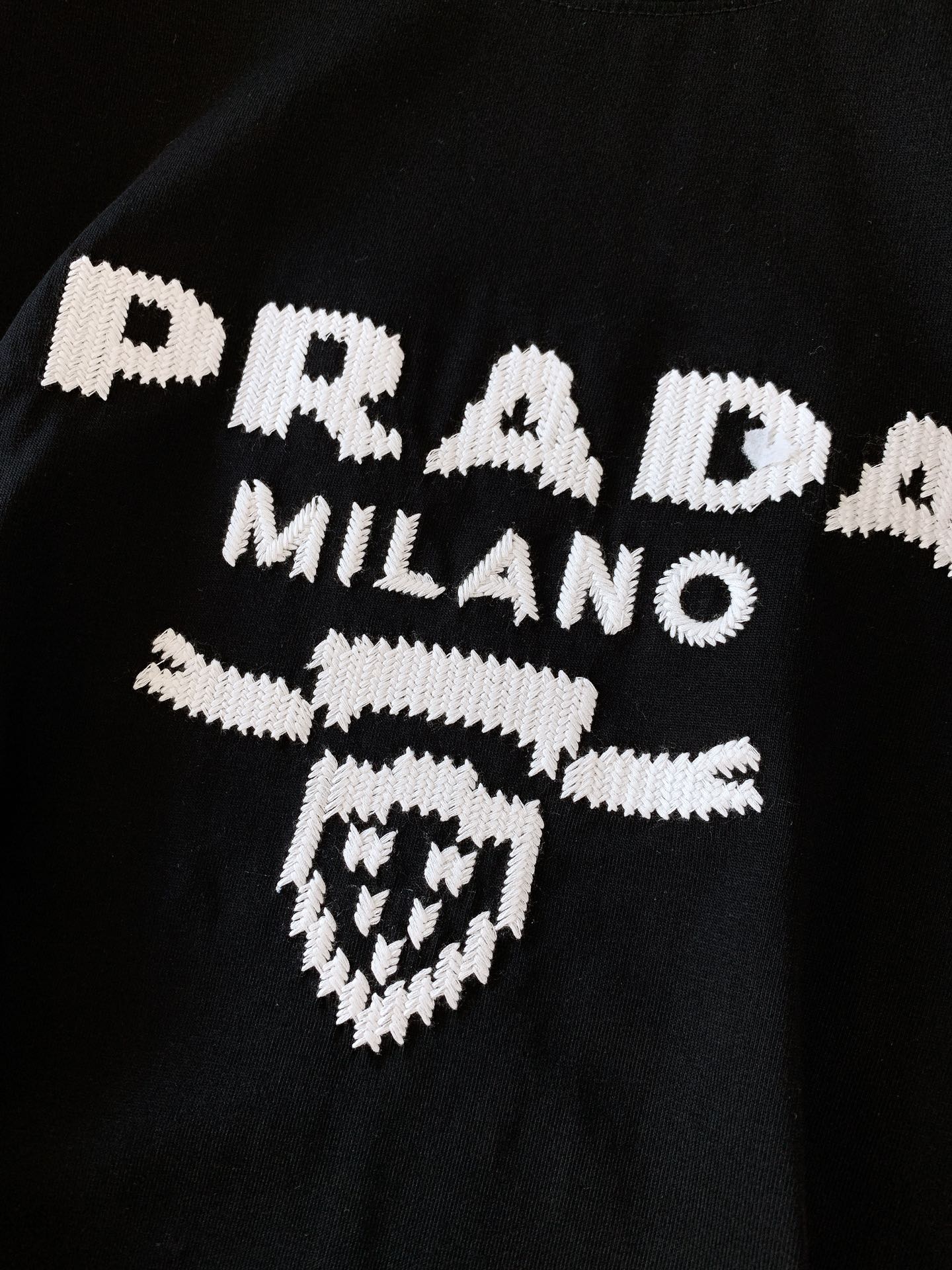 
Prada 普拉达 2025SS春夏新品 
重工刺绣T恤。胸前字母与徽章图案每一针刺绣都经过精准对位，