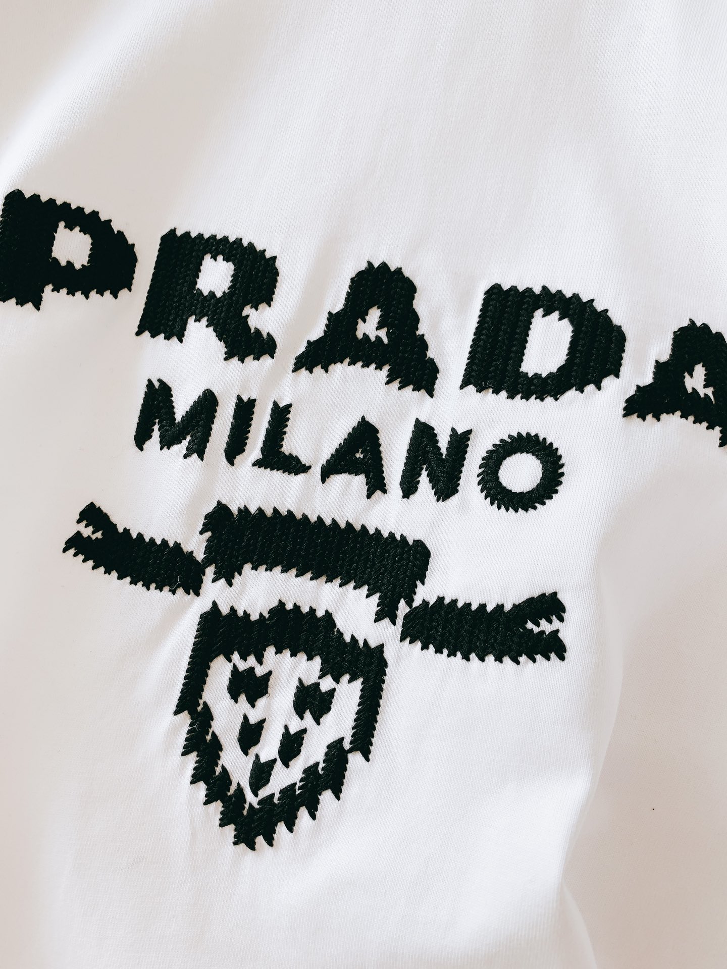 
Prada 普拉达 2025SS春夏新品 
重工刺绣T恤。胸前字母与徽章图案每一针刺绣都经过精准对位，