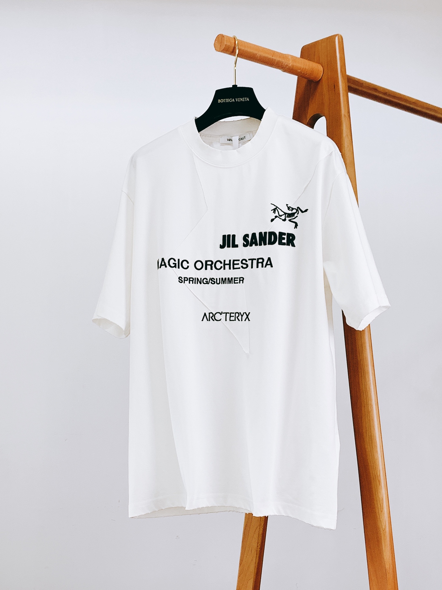 تي شيرت Arc'teryx x Jil Sander بتصميم عصري وتطريز فاخر لربيع وصيف 2025