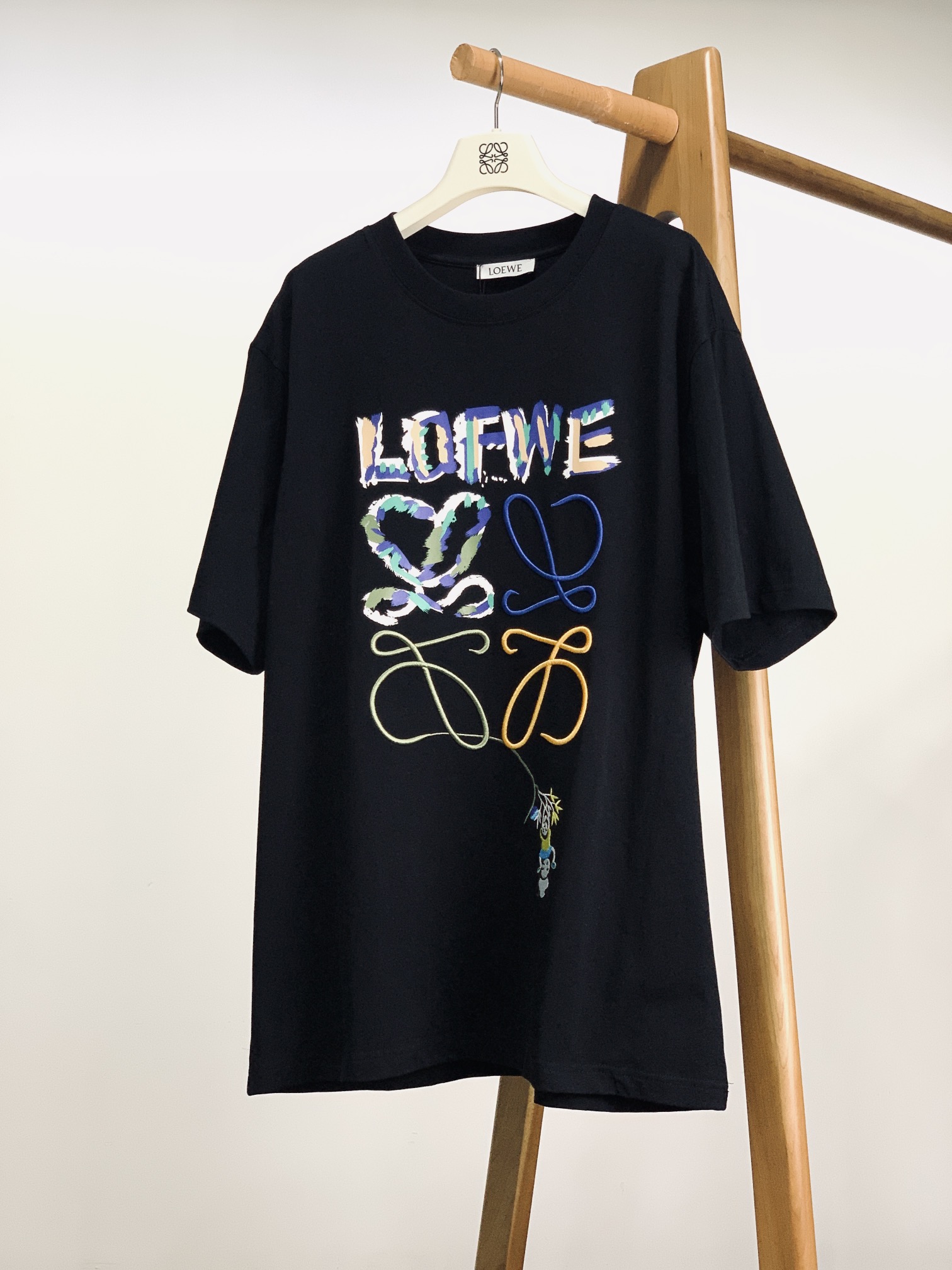 NO:432319,Loewe Embroidered printed short sleeves The brand letters on the chest are embroidered with colorful brushstrokes. The collided colors such as blue, green, and brown are as casual and eye-catching as artistic graffiti, breaking the dullness of solid colors. The iconic Anagram pattern below is outlined with three-dimensional embroidery of different colors, and the lines are flexible and entangled, making the brand symbols look artistic, making people remember the unique style of the brand at a glance. The colorful embroidery lines at the hem extend into small hanging patterns, and there are two cute panda embroidery, one is just a 'sports expert' hanging upside down, and the other is a 'strongman' who lifts upside down, with bright and story-conscious colors. High-quality pure cotton fabric is soft and skin-friendly, moderate thickness, breathable and sweat-free, and is suitable for daily wear and layering. OS loose style, the same style as men and women ………………………………………………………………………………………………………………………………………………………………………………………………………………………………………………………………………………………………………………………………………………………………………………………………………………………………………………………………………………………………………………………………………………………………………………………………………………………………………………………………………………………………………………………………………………………  SizeS-XL, loewe, loewe, T-shirt, alexander wang19860909Loewe 罗意威 刺绣印花短袖 胸前品牌字母,用彩色笔触刺绣呈现,蓝、绿、棕等色调碰撞,像艺术涂鸦般随性又吸睛,打破纯色沉闷.下方品牌标志性 Anagram 图案,以不同颜色的立体刺绣勾勒,线条灵动缠绕,把品牌符号玩出艺术感,让人一眼记住品牌的独特格调. 下摆彩色刺绣线条延伸出小挂饰般的图案,还有两只憨态可掬的熊猫刺绣,一只是倒挂树枝的 “运动达人”,一只是稳稳托举的 “大力士”,色彩明快又充满故事感. 选用优质纯棉面料,触感柔软亲肤,厚度适中,穿着透气不闷汗,日常单穿、叠穿都适配.OS宽松版型,男女同款 …………………………………………………… SizeS-XL,,loewe,loewe,T-shirt,alexander wang,Men's clothing