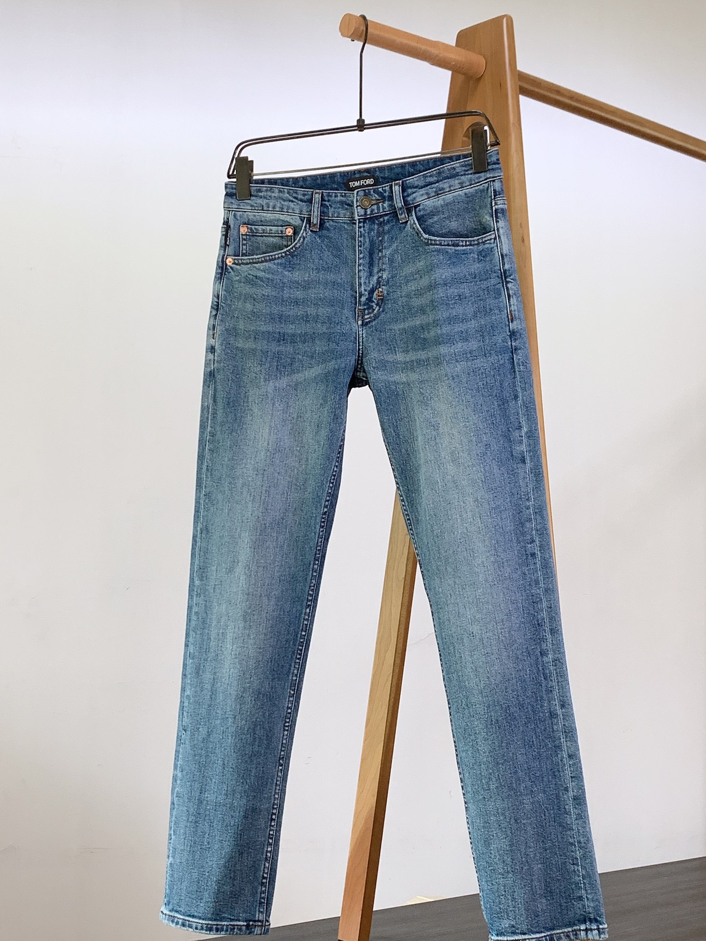 NO:525421,TOM FORD 2025FW Early Autumn New Product This jeans, mainly classic denim blue, with different shades of washing effect, presents a natural and layered visual sense, as if telling the story of time. The fabric is made of high-quality denim, which is both crisp and soft, comfortable and durable, showing a style that is both retro and practical. The brown leather sign at the back waist is stamped with a delicate brand name, and the texture of the leather adds a luxury and exquisiteness to the jeans, inadvertently showing the wearer's fashion attitude. The buttons on the waist of the trousers have been carefully designed and engraved with brand words, and metal materials are matched with retro tones. Each button is a display of quality.  .The copper rivets embroidered on the edge of the front bag not only enhance the durability of the pocket, but also add a bit of tough work style, which perfectly matches the overall denim style. The 'TF' embroidery logo in the secret area of ​​the front bag is delicate in needle, and the unique mark of the brand is low-key. The stitching on the pants is designed in contrasting colors, and the stitching is even and fine. Whether it is the splicing of the trousers or the edges of the pocket, it is handled extremely finely, which not only enhances the structural strength of the pants, but also reflects Tom Ford's ultimate pursuit of craftsmanship in details. The classic straight-pin version is very friendly to all shapes, which can effectively modify the leg shape and show neat leg lines. Whether it is paired with a simple solid-color T-shirt to create a casual and daily style, or with a shirt and leather shoes to create an urban fashion sense, this TF jeans can be easily adapted, becoming the finishing touch to enhance the texture of the outfit  . ………………………………………………………………………………………………… Size29-38,,tom ford, jeans,shirts,tees,t-shirt,alexander wang19860909TOM FORD 汤姆.福德 2025FW早秋新品 这款牛仔裤,以经典牛仔蓝为主色调,深浅不一的水洗效果,呈现出自然且富有层次感的视觉观感,仿佛诉说着岁月的故事.面料选用高品质牛仔布, 既有挺括感又不失柔软,穿着舒适且耐穿,彰显复古与实用兼具的风格 . 后腰位置的棕色皮革标牌,压印着细腻的品牌名称,皮革的质感为牛仔裤增添了一份奢华与精致,不经意间展现穿着者的时尚态度. 裤腰的纽扣经过精心设计,刻有品牌字样,金属材质搭配复古色调,每一次扣合都是对品质的彰显 .前袋边缘点缀的铜色铆钉,不仅强化了口袋的耐用性,还增添了几分硬朗的工装风格,与整体牛仔风格完美契合. 前袋隐秘处的“TF”刺绣标识,针法细腻,低调地展现品牌的独特印记 .裤子上的缝线采用对比色设计,线迹均匀细密,无论是裤身的拼接处还是口袋边缘,都处理得极为精细,不仅增强了裤子的结构强度,更在细节处体现了汤姆福特对工艺的极致追求 . 经典的直筒版型,对各种身形都十分友好,能够有效修饰腿型,展现利落的腿部线条 .无论是搭配简约的纯色T恤打造休闲日常风,还是搭配衬衫、皮鞋营造都市时尚感,这款TF牛仔裤都能轻松适配,成为提升穿搭质感的点睛之笔 . …………………………………………………… Size29-38,,tom ford,tom ford,jeans,shirts,tees，t-shirt,alexander wang,Men's clothing