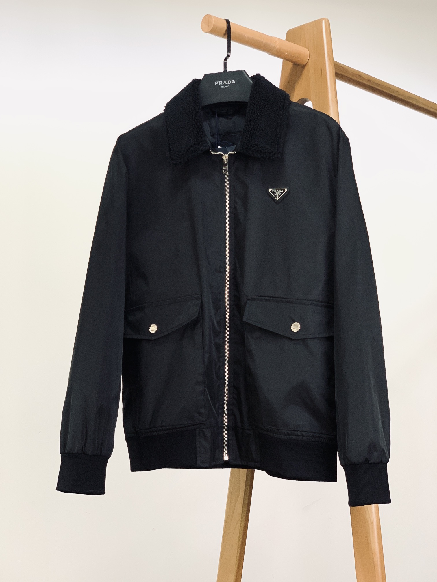 NO:595145,Prada Prada 2025FW early autumn new products  Triangle micro-label jacket with fur collar. Made of regenerated nylon fabric, it is lightweight but has excellent wear resistance and windproofness, making it easy to cope with various daily occasions. At the same time, its good breathability keeps the wearer comfortable and dry at all times, perfectly integrating environmental protection and practicality. The classic jacket design is simple yet elegant, and perfectly fits the body lines, showing a neat wearing effect. The moderate length and slim tailoring not only ensure the flexibility of movement, but also modify the body shape.  The plush collar at the neckline is a highlight of this jacket. The soft and fluffy plush not only adds a sense of warmth and luxury to the overall look, but also provides intimate care for the neck in cold weather. The plush collar has a delicate texture and uniform color, demonstrating strict control of the material.  The triangular micro logo on the front chest is one of the brand's iconic elements. The exquisite logo is made of high-quality materials, and the metallic font and frame are particularly eye-catching against the black fabric. The design of the two large pockets not only increases the practicality of the jacket, making it convenient to carry personal belongings, but also enriches the overall visual layering. The stitching on the edges of the pockets is neat and meticulous, and it is equipped with metal snaps with the brand logo. It is easy and secure to open and close, and the details show the brand's ingenuity.  The zipper is made of high-quality metal, and the puller is engraved with the brand logo. The zipper is smooth and smooth, durable and beautiful. The rib design on the cuffs and hem not only effectively prevents cold wind from entering, but also outlines neat lines, making the jacket more crisp and stylish. The design inside the jacket is equally exquisite, with product information and washing instructions clearly marked on the label. The high-quality inner fabric is not only comfortable to the touch, but also complements the outer fabric of regenerated nylon, further enhancing the wearing experience.  Size 46, length 66, chest 114, sleeve length 62, shoulder width 46.5, size 48, length 68, chest 118, sleeve length 63, shoulder width 48, size 50, length 70, chest 122, sleeve length 64, shoulder width 49.5, size 52, length 72, chest 126, sleeve length 65, shoulder width 51.  Size48-52,,prada,prada,jackets & coats,alexander wang19860909Prada 普拉达 2025FW早秋新品 毛领三角微标夹克.采用再生尼龙面料打造,质地轻盈,却拥有出色的耐磨性与防风性,能够轻松应对日常各种场合.同时,其良好的透气性,让穿着者时刻保持舒适干爽,将环保与实用完美融合.经典的夹克版型设计,简洁而不失大气,完美贴合人体线条,展现出利落的穿着效果.适中的长度搭配修身的剪裁,既保证了活动的灵活性,又能修饰身形. 领口处的毛绒领子,是这款夹克的一大亮点.柔软且蓬松的毛绒,不仅为整体造型增添了一份温暖与奢华感,更能在寒冷的天气里给予颈部贴心的呵护.毛绒领子的质感细腻,色泽均匀,彰显对材质的严格把控. 前胸饰有的三角微标,是品牌的标志性元素之一.精致的徽标采用高品质材质制作,金属质感的字体与边框,在黑色面料的衬托下格外醒目. 两个大兜袋的设计,不仅增加了夹克的实用性,方便携带随身物品,还丰富了整体的视觉层次感.兜袋边缘的缝线工整细致,搭配带有品牌标志的金属按扣,开合方便且牢固,细节之处尽显品牌的匠心. 拉链选用优质金属材质,拉头上刻有品牌标识,拉合顺滑流畅,耐用且美观.袖口和下摆处的罗纹设计,不仅能有效防止冷风灌入,还能勾勒出利落的线条,使夹克的版型更加挺括有型 . 夹克内里的设计同样精致,标签清晰标注着产品信息以及洗涤说明,优质的内里面料,不仅触感舒适,还能与再生尼龙的外层面料相得益彰,进一步提升穿着体验. 46码衣长66 胸围114 袖长62 肩宽46.5 48码衣长68 胸围118 袖长63 肩宽48 50码衣长70 胸围122 袖长64 肩宽49.5 52码衣长72 胸围126 袖长65 肩宽51 …………………………………………………… Size48-52,,prada,prada,jackets & coats,alexander wang,Men's clothing