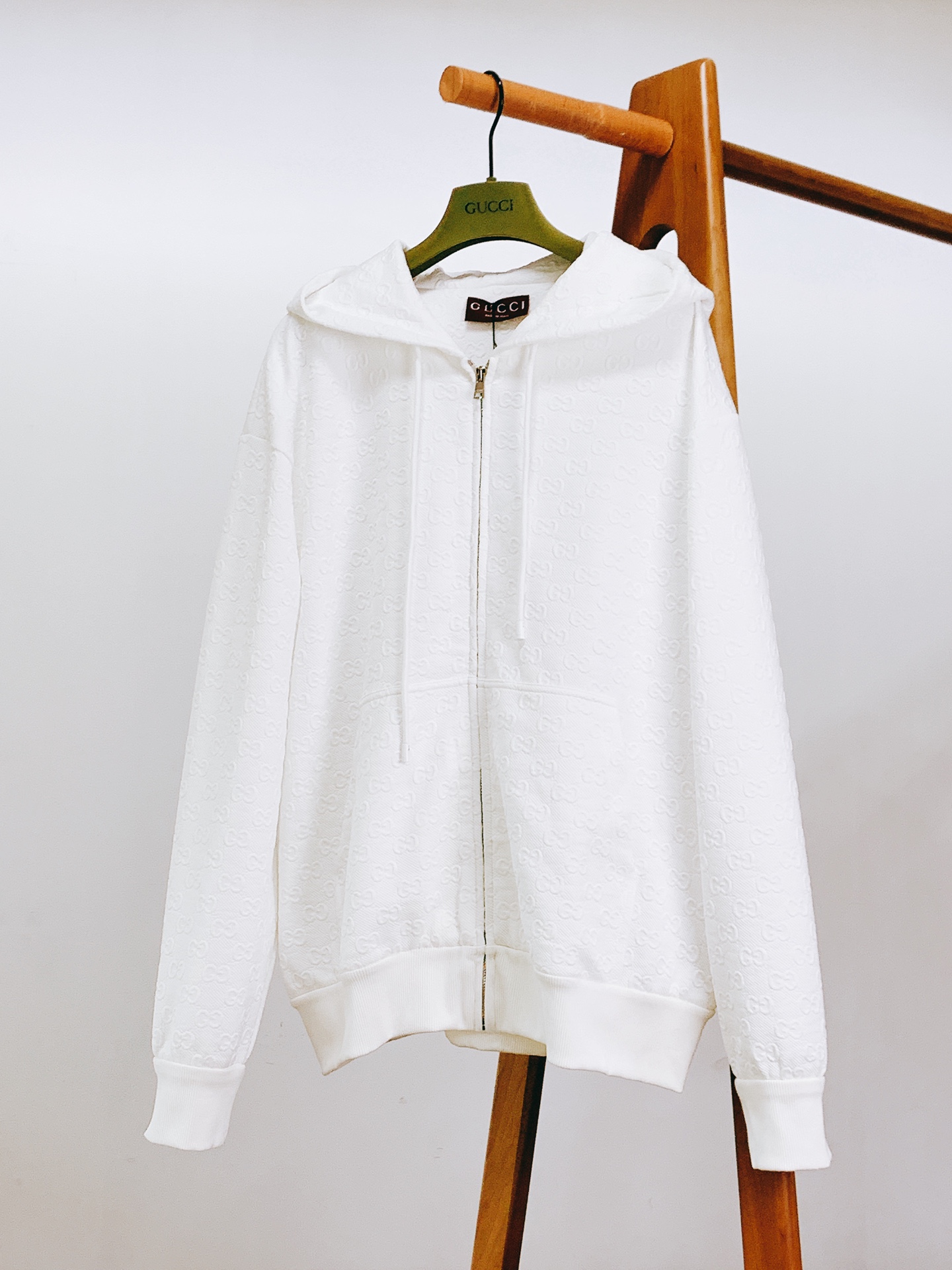 NO:692414,Gucci Embossed Knitted Zip Jacket Sweatshirt This unisex zipper jacket is a sincere work of the 2025 early autumn series, cleverly integrating marine style with the brand's classic genes. It is crafted from GG printed embossed jersey fabric, and the three-dimensional GG logo all over the body is Gucci's century-old identity mark. It has a full texture to the touch, and is visually refined and layered.  Luxurious style is shown in every detail. The custom metal zipper is engraved with clear brand words, and the smooth opening shows the level of craftsmanship. The metal buckle of the hooded drawstring is also printed with the brand logo. Every small design tells the brand's ultimate pursuit of details.  The version is a loose casual silhouette, which is very friendly to all body shapes. The fabric is cotton (the material details can be seen from the wash label), which is skin-friendly and comfortable. It can be perfectly adapted to resist the cool sea breeze when walking on the beach, or to create a casual look when going out on the street every day.  In addition to the main white model, there are also classic black options, with different colors interpreting the same high-end feel. From the sophistication of the fabric embossing to the brand recognition of the hardware accessories, everything demonstrates Gucci’s ingenuity in design and craftsmanship. It is a tool for early autumn wear that combines fashion, comfort and brand recognition. Size S, length 68, bust 122, shoulder width 55.5, sleeve length 61, size M, length 70, bust 126, shoulder width 57  Sleeve length 62 L length 72 Chest 130 Shoulder width 58.5 Sleeve length 6319860909Gucci 古驰 压花针织拉链夹克卫衣 这款男女同款拉链夹克是2025早秋系列的诚意之作,将海洋风情与品牌经典基因巧妙融合. 它采用GG印花压纹平纹针织面料匠心打造,全身满布的立体GG标识,是古驰传承百年的身份印记,触摸间质感饱满,视觉上精致且富有层次. 细节处尽显奢华格调定制金属拉链上镌刻清晰的品牌字样,顺滑拉合间尽展工艺水准；连帽抽绳的金属扣头同样印有品牌标识,每一处小设计都在诉说品牌对细节的极致追求. 版型是宽松的休闲廓形,对各种身形都十分友好.面料为棉（从洗标可见材质细节）,亲肤舒适,无论是海边漫步时抵挡微凉海风,还是日常出街打造随性造型,都能完美适配. 除了主打的白色款,还有经典黑色可选,不同色彩演绎同款高级感.从面料压花的精致度,到五金配件的品牌辨识度,每一处都彰显着古驰在设计与工艺上的匠心,是集时尚、舒适、品牌辨识度于一身的早秋穿搭利器. S码衣长68 胸围122 肩宽55.5 袖长61 M码衣长70 胸围126 肩宽57 袖长62 L码衣长72 胸围130 肩宽58.5 袖长63 XL码衣长74 胸围134 肩宽60 袖长64 …………………………………………………… SizeS-XL,,gucci,gucci,hoodie,sweatshirts,jackets & coats,hats,,Men's clothing