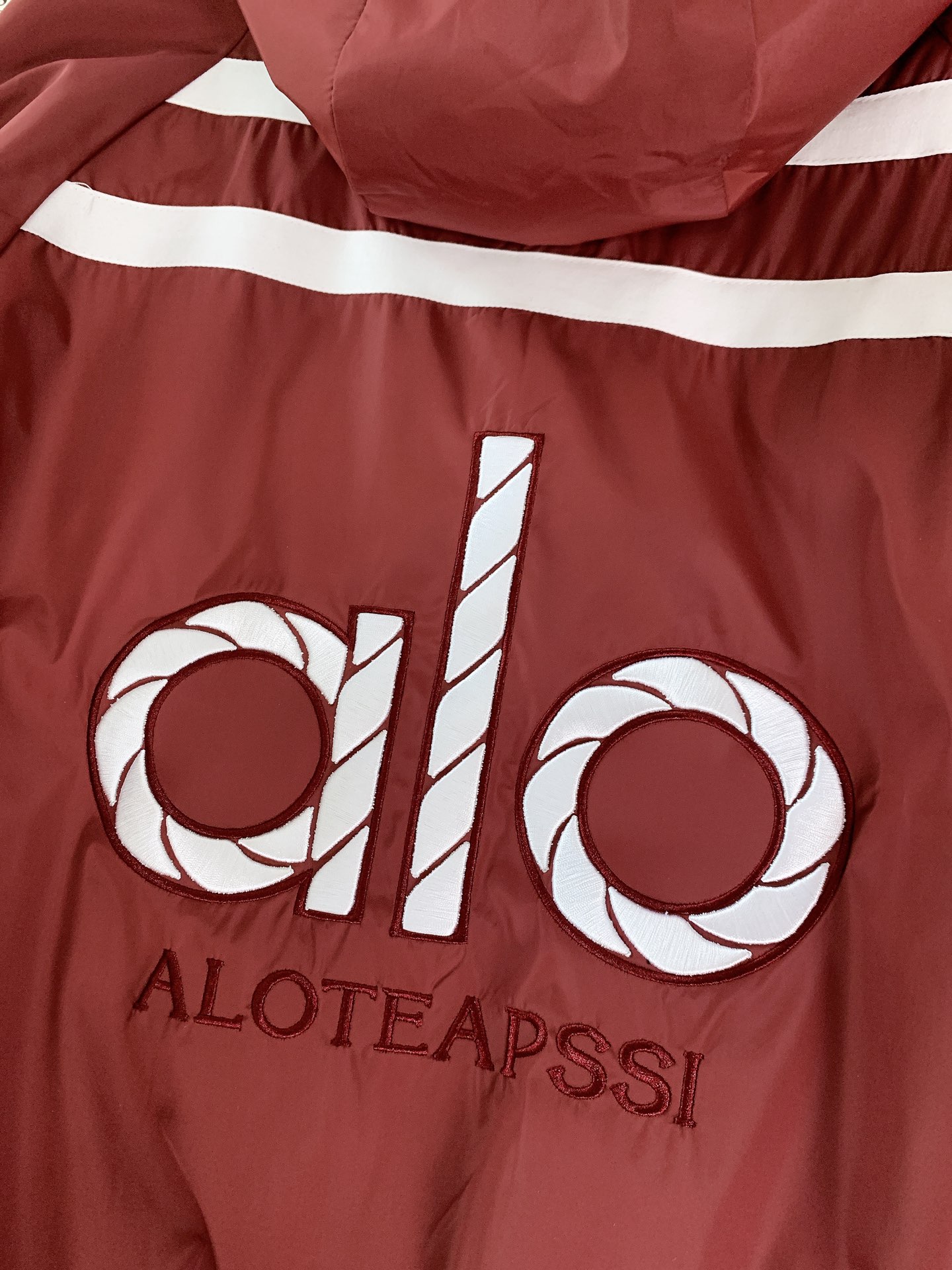 ALO 阿洛 2025FW早秋新品 连帽运动外套。它以轻量防风的面料打造利落廓形，连帽设计可随天气与造型