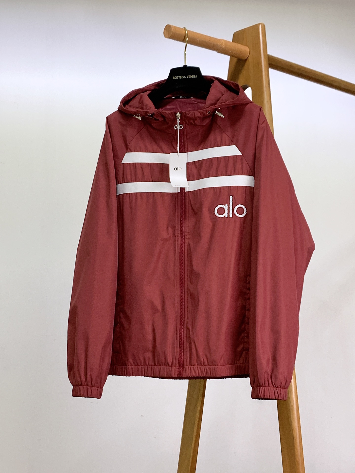 ALO 阿洛 2025FW早秋新品 连帽运动外套。它以轻量防风的面料打造利落廓形，连帽设计可随天气与造型