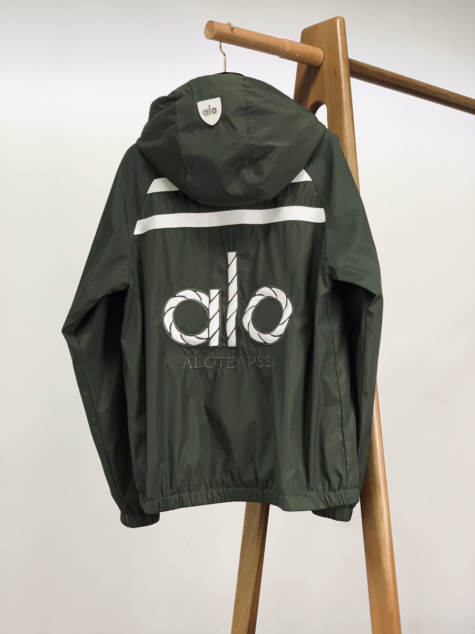 ALO 阿洛 2025FW早秋新品 连帽运动外套。它以轻量防风的面料打造利落廓形，连帽设计可随天气与造型