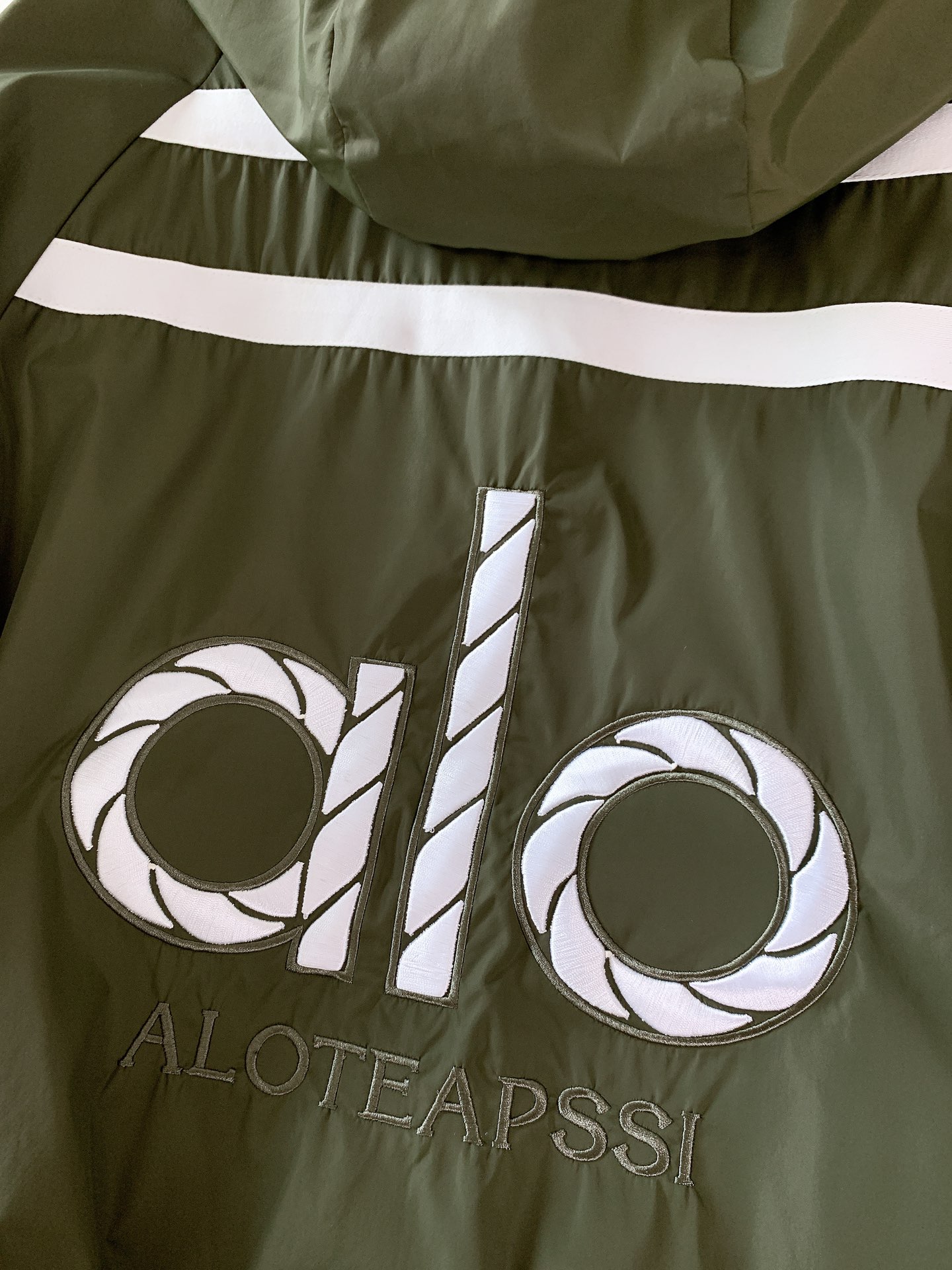 ALO 阿洛 2025FW早秋新品 连帽运动外套。它以轻量防风的面料打造利落廓形，连帽设计可随天气与造型