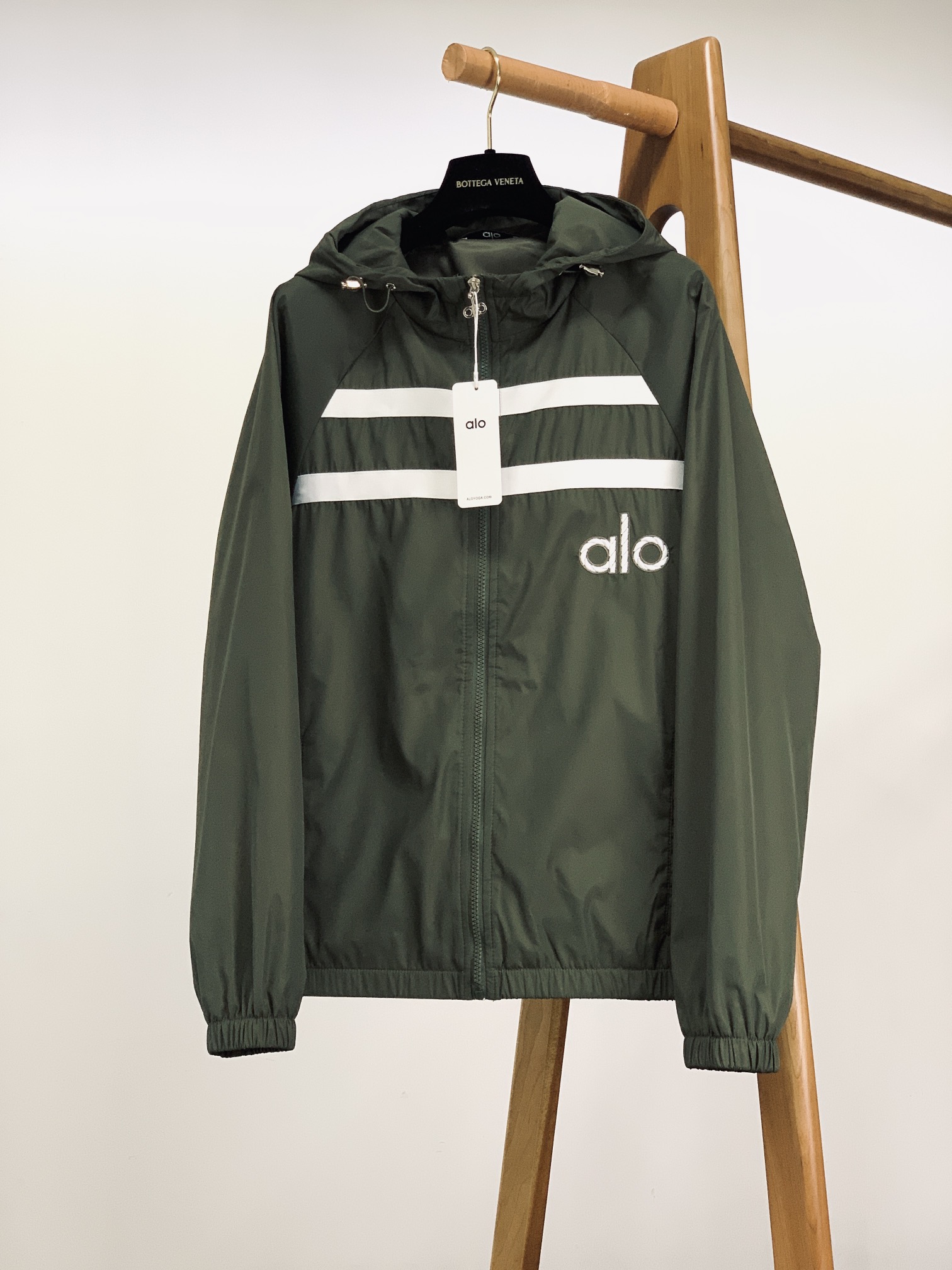 ALO 阿洛 2025FW早秋新品 连帽运动外套。它以轻量防风的面料打造利落廓形，连帽设计可随天气与造型