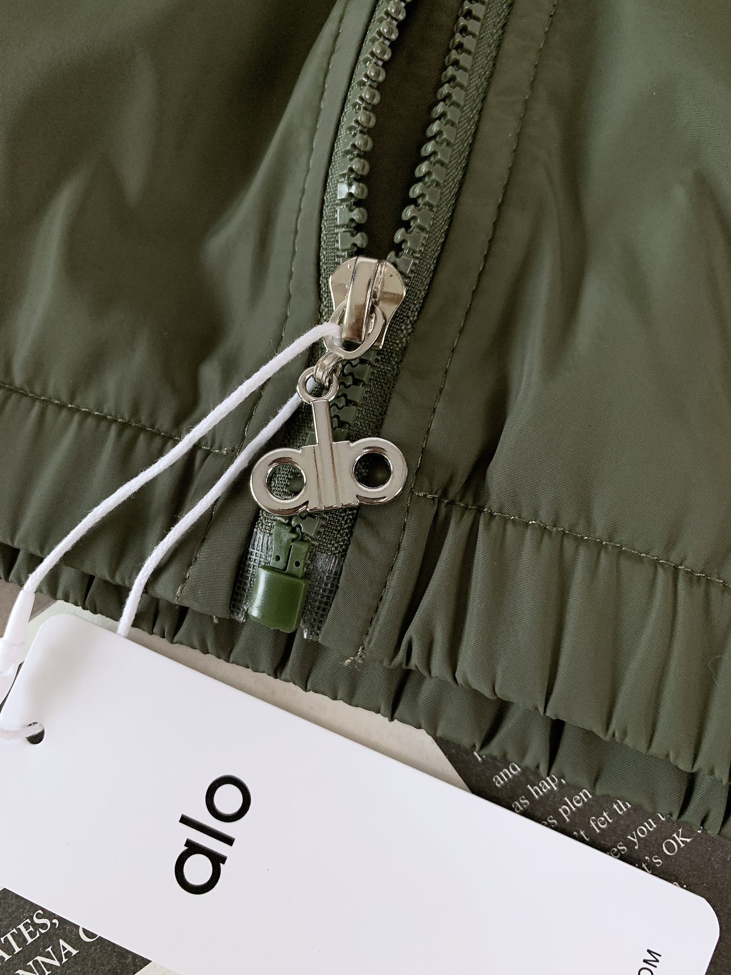 ALO 阿洛 2025FW早秋新品 连帽运动外套。它以轻量防风的面料打造利落廓形，连帽设计可随天气与造型