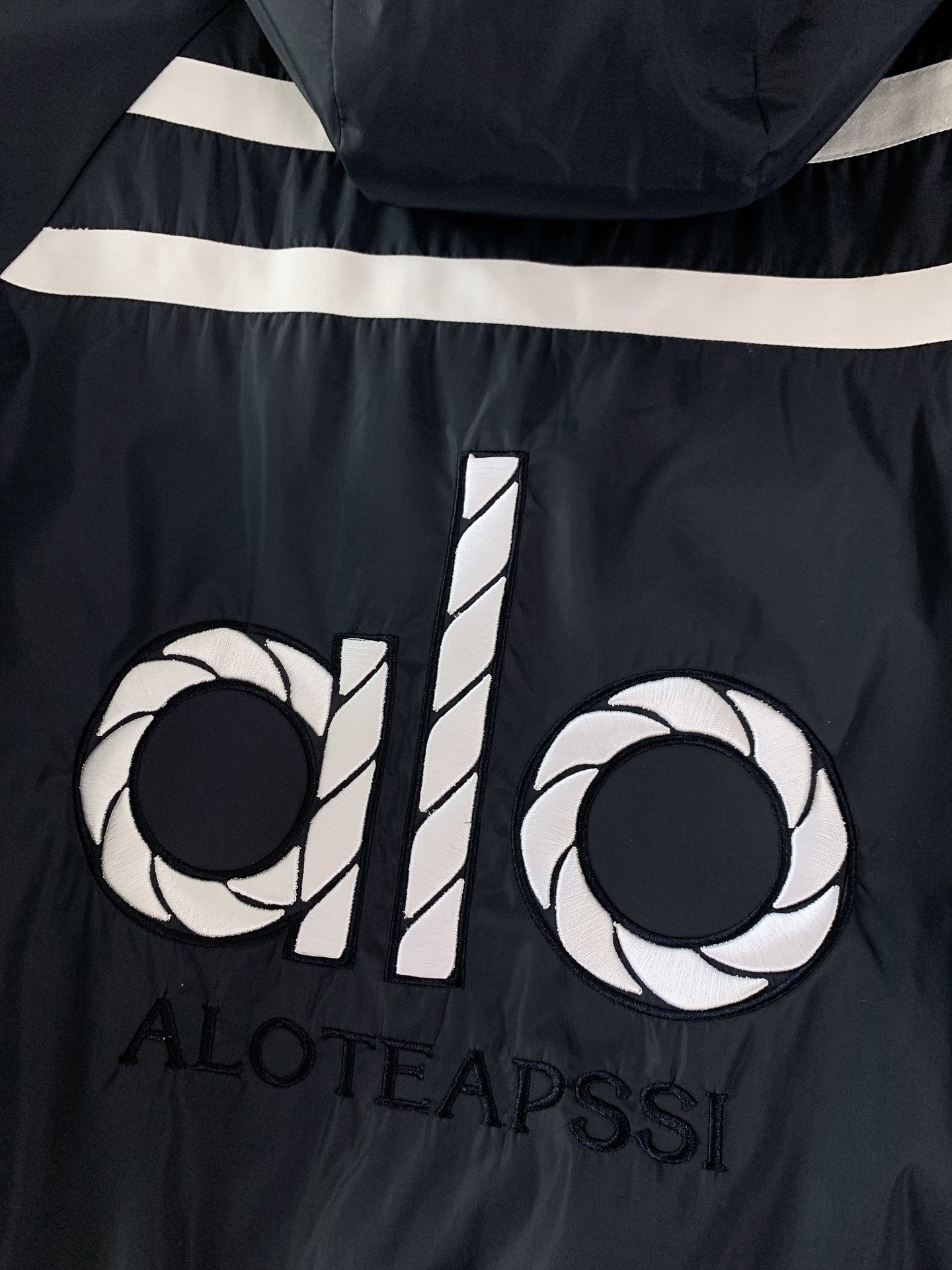 ALO 阿洛 2025FW早秋新品 连帽运动外套。它以轻量防风的面料打造利落廓形，连帽设计可随天气与造型