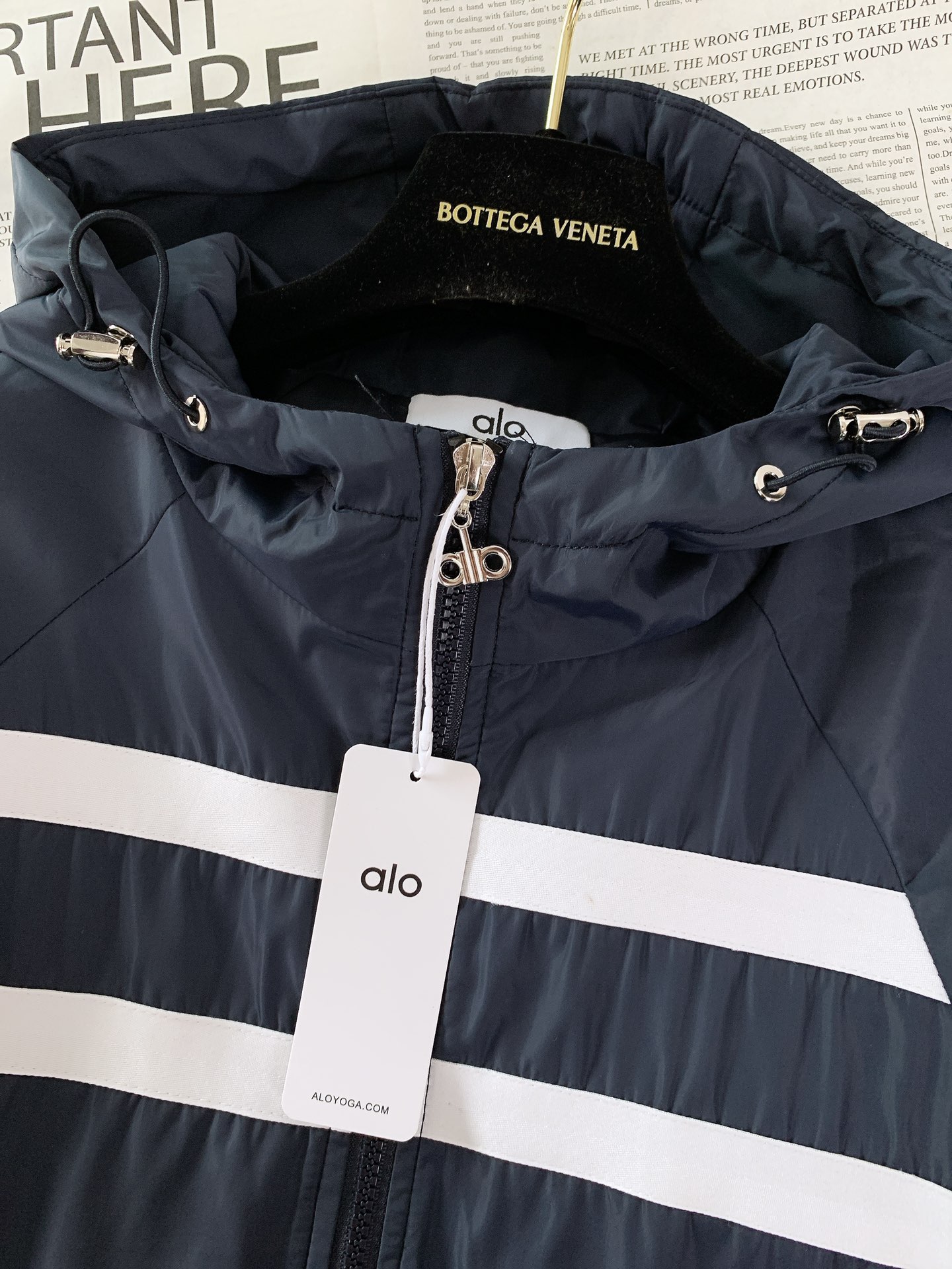 ALO 阿洛 2025FW早秋新品 连帽运动外套。它以轻量防风的面料打造利落廓形，连帽设计可随天气与造型