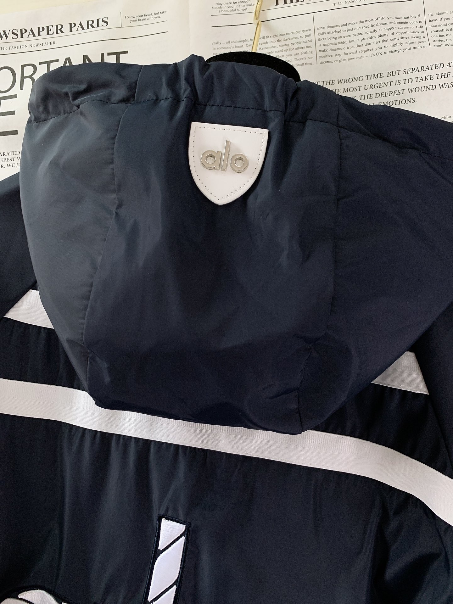 ALO 阿洛 2025FW早秋新品 连帽运动外套。它以轻量防风的面料打造利落廓形，连帽设计可随天气与造型