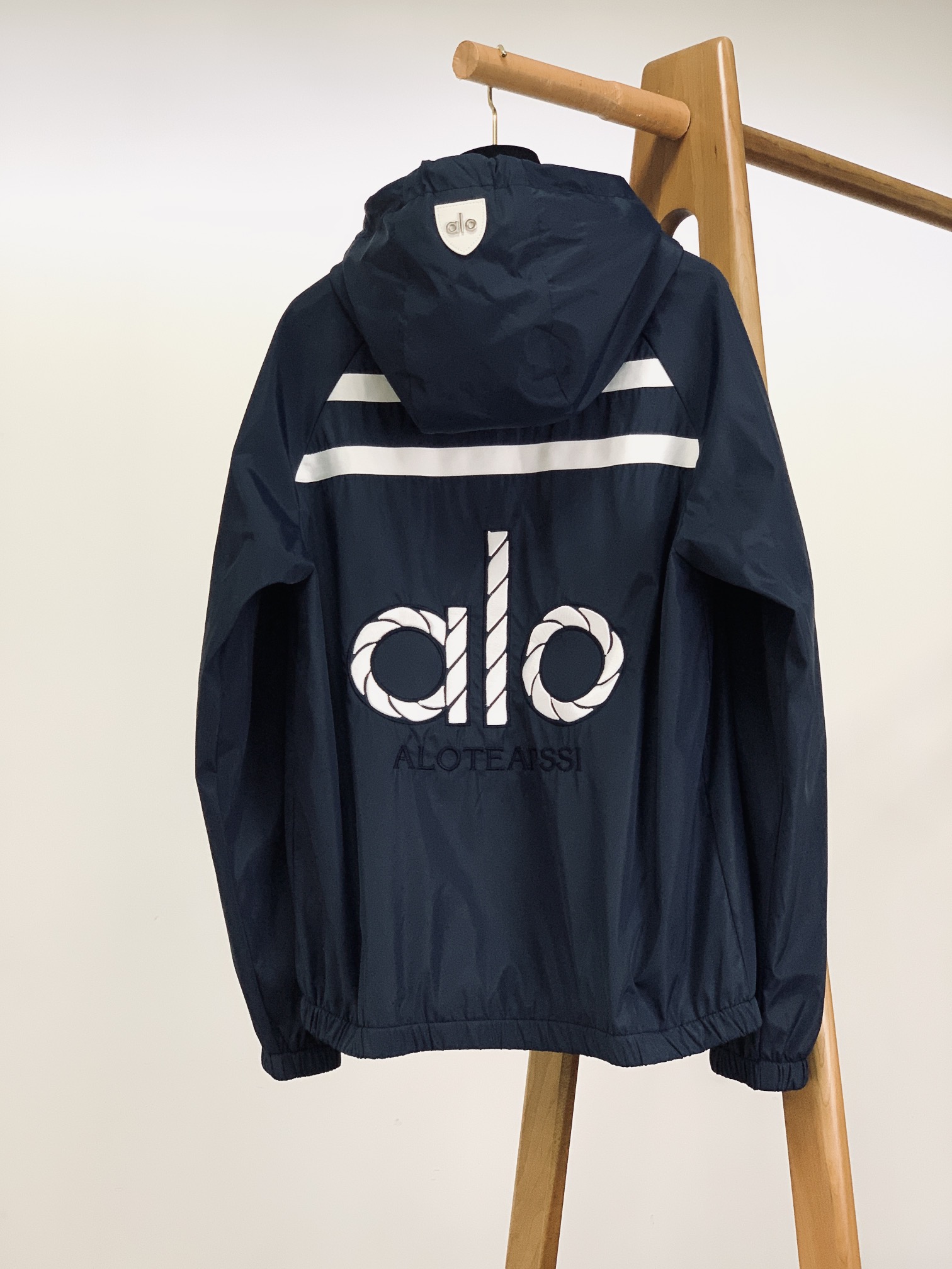 ALO 阿洛 2025FW早秋新品 连帽运动外套。它以轻量防风的面料打造利落廓形，连帽设计可随天气与造型