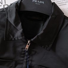 Prada 普拉达 2025FW早秋新品 工装风夹克外套。以利落的翻领工装廓形为骨架,黑色哑光面料高级感 Prada 普拉达 2025FW早秋新品 工装风夹克外套。以利落的翻领工装廓形为骨架,黑色哑光面料高级感