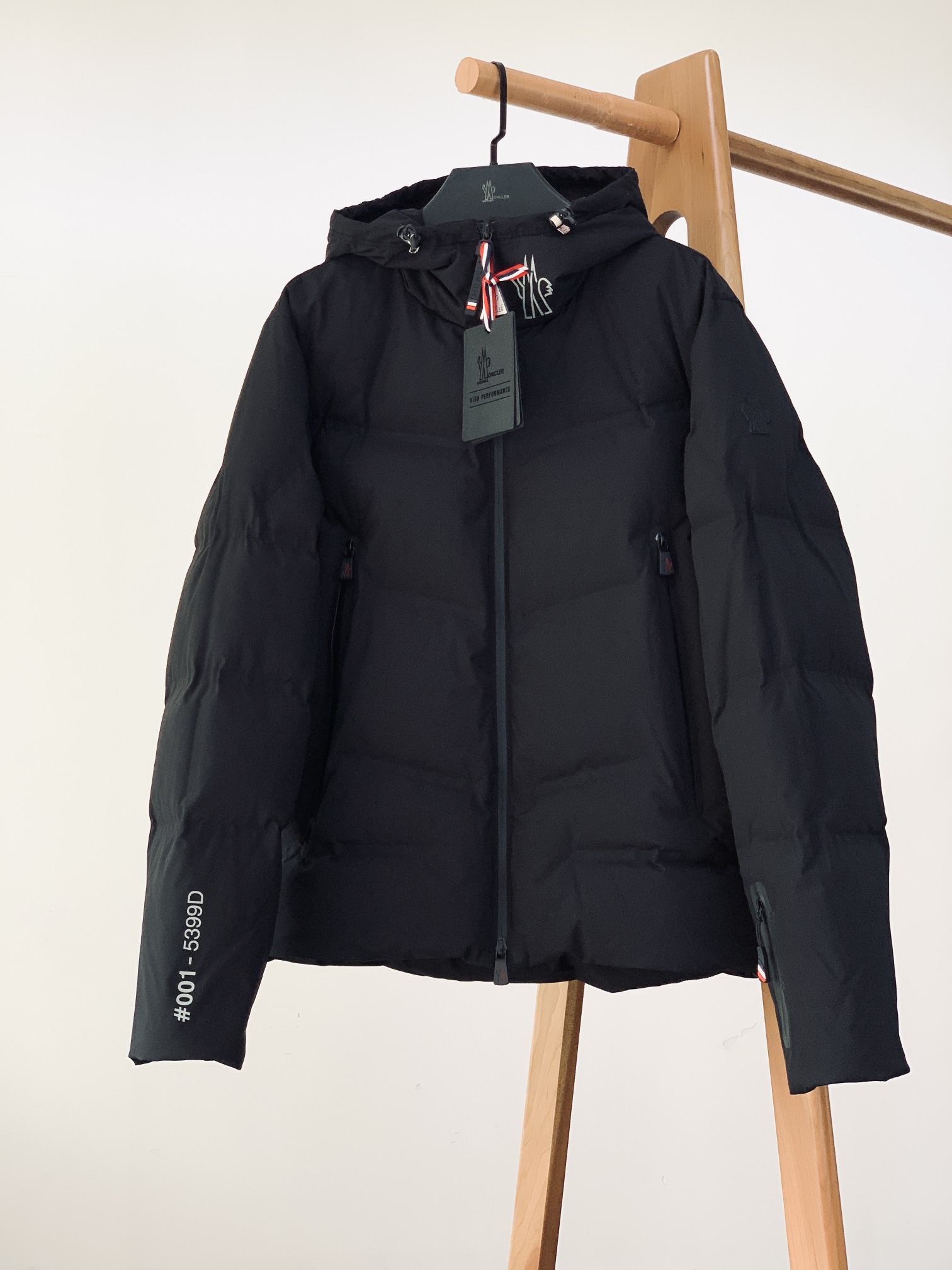 NO:692422,Moncler's Angren ski hooded down jacket sews 'outdoor functionality' and 'luxury texture' into every inch of stitching. 1. The warm code of 90 velvet filling  It is filled with No. 90 large down, which has full fluffiness and warmth - it is as light as nothing but can withstand severe cold. It is soft as 'wrapped in clouds' when worn outdoors. It is a hard-core protection against wind and snow when walking outdoors. Each goose down is strictly screened to ensure the fluffiness and cleanliness, allowing warmth from the inside to the outside without any dead ends. 2. Identity narrative in the logo  The three-dimensional logo on the sleeve arm is full of texture, and the matte material has a low-key sense of luxury in the light. It is a classic symbol of 'low-key luxury' in the mouth, and the identity can be recognized at a glance. The customized nameplate #001 - 5399D is printed with an exclusive number, which engraves the 'sense of limited edition' into the design; the combination of 'DAY-NANIC' letters and the brand logo on the back makes the street sense and high luxury sense collide to create a unique style. 3. Duo of hardware function and texture  The multi-zipper system's main zipper and pocket zippers are made of customized hardware, with the brand logo embossed on the slider. The smooth damping feeling when pulling is a detailed reflection of Italian craftsmanship. The hidden zipper pockets on the sleeve arms not only meet the needs of outdoor storage, but also make the design full of layering.  Adjustment buckles: The brim adjustment buckle and the hem adjustment buckle are both functional hardware. The neat 'click' sound during operation is an intuitive expression of outdoor functions. The red, white and blue webbing embellishments inject the brand's iconic vibrant colors into the whole. 4. The ingenuity code of the Italian craftsmanship workshop  The outer layer of the windproof fabric is made of high-density windproof fabric, which has excellent waterproof and windproof properties, and can handle rain and snow weather with ease; the bright lining on the inside makes the goose down filling more even, and is less likely to clump after long-term wear. Every detail of the stitching is processed with precision, and the stitch density and direction strictly follow the outdoor clothing standards, which not only ensures the structural stability of the down jacket, but also allows 'luxury craftsmanship' to take root in functional clothing.  From the Alps to the urban streets, the rigorous craftsmanship of this down jacket tells a story of 'luxury is more than the surface, and warmth is more than the filling'. Length 1 size 71 Chest 116 Shoulder width 48 Size 2 length 72 Bust 120 Shoulder width 49 Size 3 length 73 Chest 124 Shoulder width 50 Length 4 size 74 Chest 128 Shoulder width 51 Length 5 size 75  Bust 132, Shoulder Width 52…………………………………………………… Size1-5,,Moncler,down jacket,hats,19860909Moncler 蒙口 Angren滑雪连帽羽绒服,把“户外机能”与“奢侈质感”缝进了每一寸针脚里. 一、填充90绒的温暖密码 采用90号大朵羽绒填充,蓬松度与保暖性拉满——轻若无物却能抵御严寒,穿上身是“被云朵包裹”的柔软,户外行走时是“对抗风雪”的硬核防护.每一朵鹅绒都经过严格筛选,确保蓬松度与洁净度,让温暖从里到外,毫无死角. 二、标识Logo 里的身份叙事 袖臂徽标立体徽标质感十足,哑光材质在光线里低调泛着高级感,是蒙口“低调奢华”的经典符号,一眼识身份. 定制铭牌#001 - 5399D 专属编号印花,把“限量感”刻进设计里；后背“DAY-NANIC”字母与品牌标识的组合,让街头感与高奢感碰撞出独特风格. 三、五金机能与质感的双重奏 多拉链系统主拉链、口袋拉链均采用定制五金,拉头压印品牌标识,拉合时的顺滑阻尼感,是意大利工艺的细节体现；袖臂隐藏式拉链口袋,既满足户外储物需求,又让设计充满层次感. 调节扣具帽檐调节扣、下摆调节扣均为功能性五金,操作时“咔嗒”一声的利落感,是户外机能的直观表达；红白蓝织带点缀,为整体注入品牌标志性的活力色彩. 四、工艺意大利工坊的匠心暗语 防风面料外层采用高密度防风面料,防水抗风性能优异,应对雨雪天气也能从容自在；内里亮面衬里,让鹅绒填充更均匀,久穿不易结团. 细节缝合每一处缝线都经精密处理,针脚密度与走向严格遵循户外服饰标准,既保证了羽绒服的结构稳定性,又让“奢侈工艺”在机能服饰里落地生根. 从阿尔卑斯雪山到都市街头,这件羽绒服用严谨的工艺,讲述一个“奢华不止于表面,温暖不止于填充”的故事. 1码衣长71 胸围116 肩宽48 2码衣长72 胸围120 肩宽49 3码衣长73 胸围124 肩宽50 4码衣长74 胸围128 肩宽51 5码衣长75 胸围132 肩宽52 …………………………………………………… Size1-5码,,Moncler,down jacket,hats,,Men's clothing
