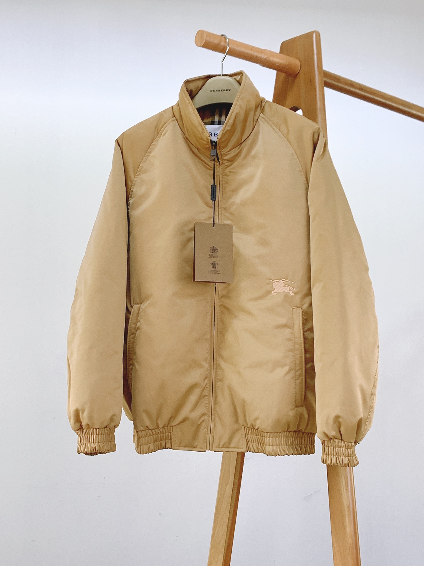 NO:595136,Burberry's new 2025 FW autumn and winter stand-up collar down jacket brings the luxurious warmth of British plaid into autumn and winter. It is filled with 90 white duck down, has high fill power, strong temperature locking properties, is lightweight without bulk, and can easily cope with temperatures of 5-15°C. The classic camel plaid lining has its own iconic British genes. Unzip it for a low-key luxury feel.  Solid color stand-up collar version (elegant black/beige two-color optional), knight embroidery logo of the same color on the chest, exquisite but not exaggerated; customized zipper puller engraved with brand logo, smooth and durable; elastic cuffs/hem tightly sealed and not caught in the wind; quilting is even and neat, with fine stitching and no exposed threads, full texture. Wear coats/windbreakers layered in autumn and winter, or wear alone to cope with the temperature difference between morning and evening, both warmth and style.  ……………………………………………………………… SizeM-3XL,,burberry,burberry,jackets & coats,down jacket,alexander wang19860909Burberry 巴宝莉 2025FW秋冬新品 立领夹克羽绒服把英伦格纹的奢暖穿进秋冬 填充90白鸭绒,蓬松度高、锁温性强,轻量无臃肿感,轻松应对5-15℃气温；经典驼色格纹衬里,自带标志性英伦基因,拉开拉链即是低调奢感. 纯色立领版型（雅黑/浅驼双色可选）,胸前同色系骑士刺绣标,精致不浮夸；定制拉链头刻有品牌标识,顺滑耐用；袖口/下摆弹力收边,紧密锁温不钻风；绗缝走线均匀工整,车线细密无外露线头,质感拉满.秋冬叠穿大衣/风衣,或单穿应对早晚温差,保暖与造型感兼备. …………………………………………………… SizeM-3XL,,burberry,burberry,jackets & coats,down jacket,alexander wang,Men's clothing