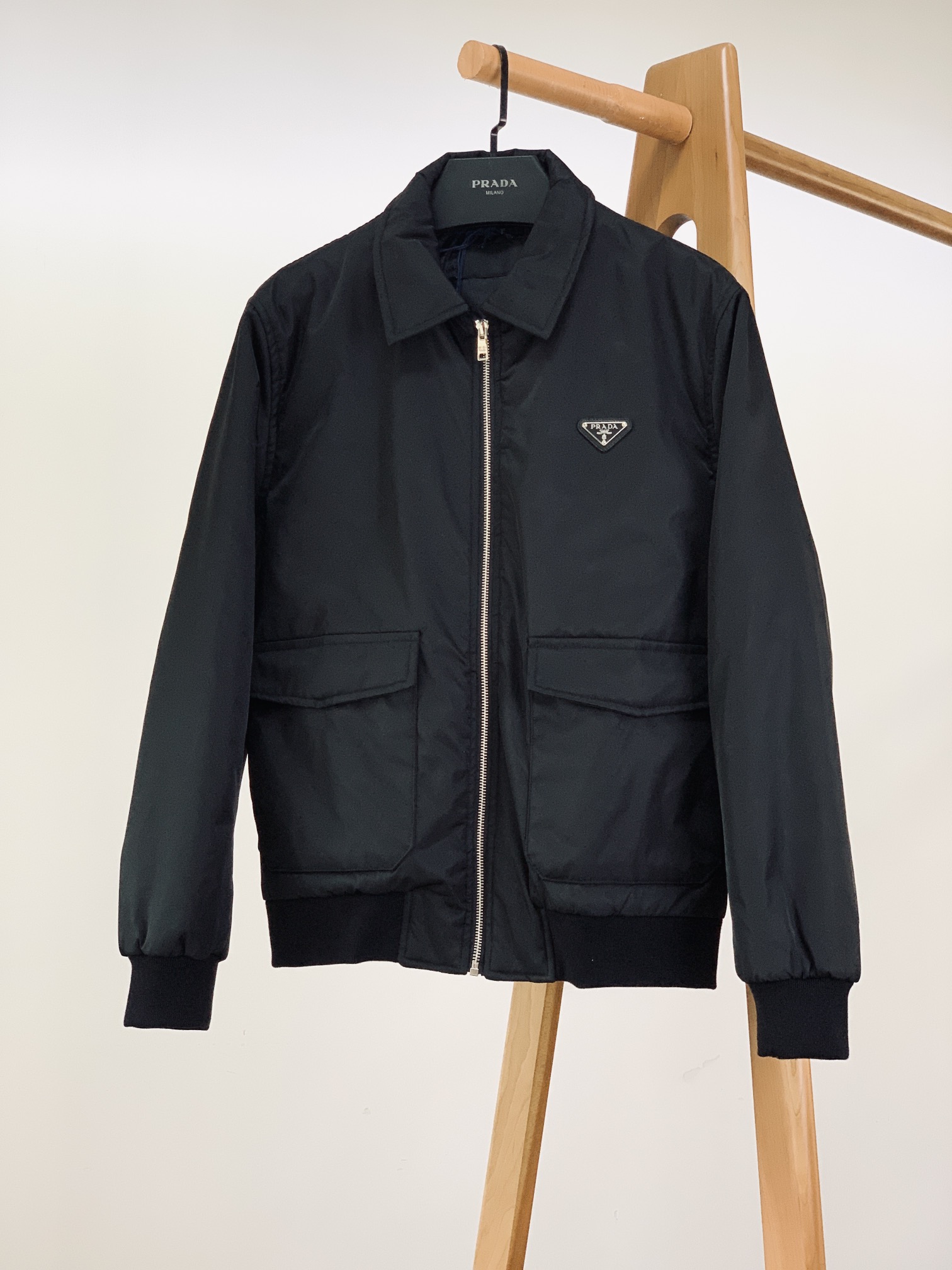 NO:595176,Prada's 2025FW early autumn new product, large lapel pocket jacket. It is made of the iconic RE-NYLON regenerated nylon fabric (marked on the label), with a fine matte luster on the surface. It is wrinkle-resistant and slightly waterproof. It is lightweight and weightless, and has the unique stiff texture of the luxury brand. It is a practical item that 'will not break down for daily wear'. 'Prad* logo system' in the details 1.  The classic triangle logo is low-key and recognizable. The triangle logo on the front chest is made of a combination of 'leather base + metal letters', and the edges are fixed with rivets. It retains the brand's iconic visual symbols without being too ostentatious. It is a hidden luxury detail that 'people who understand will naturally understand'. 2. The zipper and hardware texture are hidden in the details. The placket is equipped with a custom metal zipper, with the brand letter logo engraved on the chain head. The chain teeth are smooth and wear-resistant, and the damping feeling when opening and closing just reflects the precision of the craftsmanship;  The pocket buttons are also printed with the brand logo, and the metallic texture and nylon fabric create a material collision, and the ingenuity can be seen in the small details. Style and practical design 1. The lapel design is suitable for multiple scene styles. The lapel adopts a slightly wide shoulder line + natural drape arc, which can be suitable for casual wear (with T-shirts/sweatshirts) and light business scenes (with a shirt), which is the core advantage of 'one garment for multiple wear'. 2. The balance between practicality and aesthetics of large pocket bags  The three-dimensional large pockets on both sides adopt a 'patch + flap' design. The capacity of the bag is enough to store daily items such as mobile phones and keys. The routing of the bag opening is seamlessly connected with the body, keeping the overall visual simplicity and neatness. 3. Ribbed details can lock in temperature and shape. High-elastic ribs of the same color on the cuffs and hem closely fit the body curves, which can not only lock in heat and avoid wind drills, but also tighten the shape, so that the loose jacket will not look bloated and adapt to different body shapes.  As the core item of the season, it incorporates the concept of pragmatic luxury into every detail - the environmentally friendly gene of regenerated nylon, the brand recognition of the triangle logo, and the adaptability to wear in multiple scenes, making it not only a comfortable choice for daily commuting, but also a textured item that shows taste. Size 46, length 64, chest 114, shoulder width 45.5, sleeve length 61, size 48, length 66, chest 118, shoulder width 47, sleeve length 62  Size 50, length 68, chest 122, shoulder width 48.5, sleeve length 63, size 52, length 70, chest 126, shoulder width 50, sleeve length 64...19860909Prada 普拉达 2025FW早秋新品 翻领大兜袋夹克.采用标志性RE-NYLON再生尼龙面料（标签标注）,表面呈现细腻的哑光光泽,兼具抗皱性与轻微防水性,轻量无负重感的同时,自带奢牌独有的挺括质感,是“日常穿不垮”的实穿型单品. 细节里的「Prad*标识系统」 1. 经典三角徽标低调的辨识度 前胸的三角徽标采用“皮革底+金属字母”组合工艺,边缘以铆钉固定,既保留了品牌标志性视觉符号,又不会过于张扬,是“懂的人自然懂”的隐奢细节. 2. 拉链与五金质感藏在细节里 门襟配置定制金属拉链,链头刻有品牌字母标识,链齿顺滑耐磨,开合时的阻尼感恰好体现工艺精度； 兜袋纽扣同样印有品牌标识,金属质感与尼龙面料形成材质碰撞,小细节里见匠心. 版型与实用设计 1. 翻领设计适配多场景风格 翻领采用微宽肩线+自然垂坠弧度,既能适配休闲穿搭（搭T恤/卫衣）,也能融入轻商务场景（内搭衬衫）,是“一衣多穿”的核心优势. 2. 大兜袋实用与美学的平衡 两侧立体大兜袋采用“贴袋+盖口”设计,袋身容量足够收纳手机、钥匙等日常物品,袋口走线与衣身无缝衔接,保持整体视觉的简洁利落. 3. 罗纹细节锁温与塑形兼顾 袖口、下摆的同色高弹罗纹,紧密贴合身体曲线,既能锁住热量、避免风钻,又能收束版型,让宽松的夹克不会显得臃肿,适配不同身形. 作为当季的核心单品,它把实用主义奢品理念揉进了每一处细节——再生尼龙的环保基因、三角标的品牌辨识度、多场景的穿搭适配性,让它既是日常通勤的舒适之选,也是彰显品味的质感单品. 46码衣长64 胸围114 肩宽45.5 袖长61 48码衣长66 胸围118 肩宽47 袖长62 50码衣长68 胸围122 肩宽48.5 袖长63 52码衣长70 胸围126 肩宽50 袖长64 …………………………………………………… Size46-52,,prada,prada,hoodie,sweatshirts,jackets & coats,shirts,tees，t-shirt,alexander wang,Men's clothing