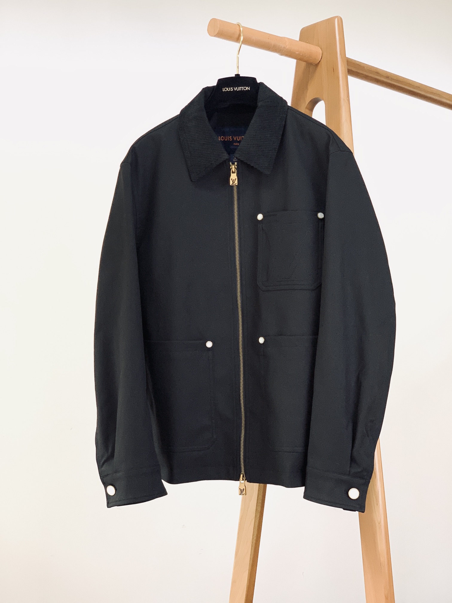 NO:595142,LouisVuitton Louis Vuitton 2025FW new autumn and winter products  Black workwear-style jacket. It is made of high-density black fabric, with a crisp texture and good drape, taking into account both durability and comfort. The style is loose workwear style, suitable for various wearing scenarios, and has a relaxed and high-end feel in leisure. The collar is made of corduroy material of the same color, with rich texture and texture, forming a material collision with the smooth fabric; double zipper closure, retro brass color enhances the texture, smooth and recognizable;  The chest pocket is embroidered with the LV pattern in the same color stitching, which hides the brand genes in a low-key manner, and the luxury style is visible in the details; the pockets and cuffs are equipped with white mother-of-pearl + brass-edged buttons, the warm luster of the mother-of-pearl echoes the metallic texture, and is full of sophistication. There are body pockets and hidden pockets on the front, which are both decorative and practical; a leather logo patch is sewn on the back to enhance the brand recognition in a low-key manner; this jacket is simple and low-key, with a fashionable and versatile upper body, making it a must-have item in the spring and autumn wardrobe.  ……………………………………………………………… SizeM-3XL,,louis vuitton,louis vuitton,louis vuitton,jackets & coats,alexander wang19860909LouisVuitton 路易威登 2025FW秋冬新品 黑色工装风外套.采用高密度黑色织物面料,质感挺括且垂坠感佳,兼顾耐用性与舒适体感；版型为宽松工装风,适配多元穿搭场景,休闲中自带松弛高级感.衣领选用同色系灯芯绒材质,纹理质感丰富层次,与光滑面料形成材质碰撞；双拉链开合,复古黄铜色泽提升质感,拉合顺畅且辨识度十足； 胸前口袋处采用同色线迹绣制LV图案,低调中暗藏品牌基因,细节处见奢品格调；口袋、袖口均搭配白贝母+黄铜包边纽扣,贝母的温润光泽与金属质感呼应,精致度拉满.前侧设立体贴袋+暗袋,兼具装饰性与实用性；后背缝制皮革标识贴片,低调强化品牌辨识度；这件外套简约低调,上身时尚百搭,春秋衣橱必备单品. …………………………………………………… SizeM-3XL,,louis vuitton,louis vuitton,louis vuitton,jackets & coats,alexander wang,Men's clothing