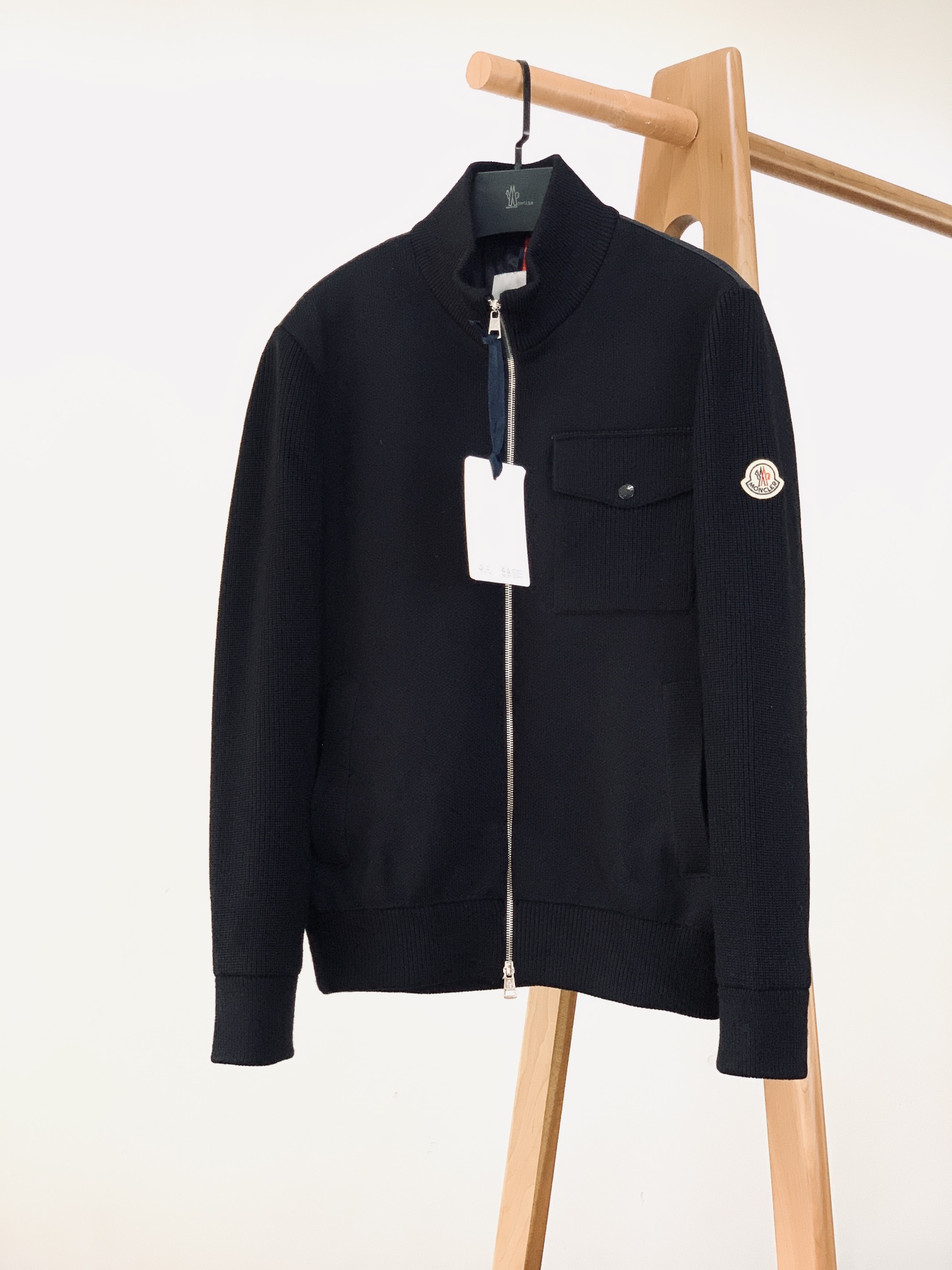 NO:595171,Moncler muffled knitted splicing down jacket interprets low-key luxury in urban winter. The front of the main splicing is made of high-density wool blended knitting, with a texture as delicate as cashmere and skin-friendly; the back is made of matte nylon, with wavy quilting technology, and locked in 90 white duck down. It is light and fluffy but can withstand low temperatures around 0℃, making it feel weightless when worn in winter; two-tone adaptation  The black model is all black knitted + matte black down, with a cool and high-end feel, making it an 'aura shirt' for work and dinner; the navy model, deep indigo knitted + dark patterned navy down, has a warmer tone and is suitable for casual and light business scenes. The red, white and blue embroidered logo on the iconic badge sleeve is more refined and recognizable on the dark base;  Hardware and Craftsmanship The customized metal zipper is engraved with the brand logo, which combines smoothness and durability; the same-color embossed buttons on the chest patch pocket and the red and white webbing decoration inside, every detail hides the rigor of Italian craftsmanship; the anti-counterfeiting certification has a built-in embossed logo tag + exclusive QR code, which is not only an authentic mark, but also brings texture and quality to the fore.  It is the 'aura blessing' when commuting. When coldness and gentleness coexist here, this ready-to-wear is the 'high-end feeling that is not tired of wearing' in the winter wardrobe. ……………………………………………… Size 1-5, Moncler, down jacket, alexander wang19860909Moncler 蒙口 针织拼接羽绒服 诠释都市冬日的低调奢华. 主体拼接正面采用高密度羊毛混纺针织,肌理细腻如羊绒般亲肤；背部则是哑光尼龙材质,搭配波浪形绗缝工艺,锁入90白鸭绒,轻量蓬松却能抵御0℃左右低温,冬日穿着无负重感； 双色调适配 黑色款全黑针织+哑光黑羽绒,自带冷冽高级感,是职场与晚宴的「气场战袍」； 藏青色款深靛针织+暗纹藏青羽绒,色调更显温润,适配休闲与轻商务场景. 标志性徽章袖身的红白蓝刺绣徽标,在深色基底上更显精致辨识度； 五金与工艺定制金属拉链刻有品牌标识,顺滑度与耐用性兼具；胸前贴袋的同色压纹纽扣、内里的红白织带装饰,每一处细节都藏着意式工艺的严谨； 防伪认证内置压印徽标吊牌+专属二维码,既是正品标识,也让质感与品质双重落地. 它是通勤时的「气场加持」当冷冽与温软在此共生,这件成衣就是冬日衣橱里「穿不腻的高级感」. …………………………………………………… Size1-5码,,Moncler,down jacket,alexander wang,Men's clothing