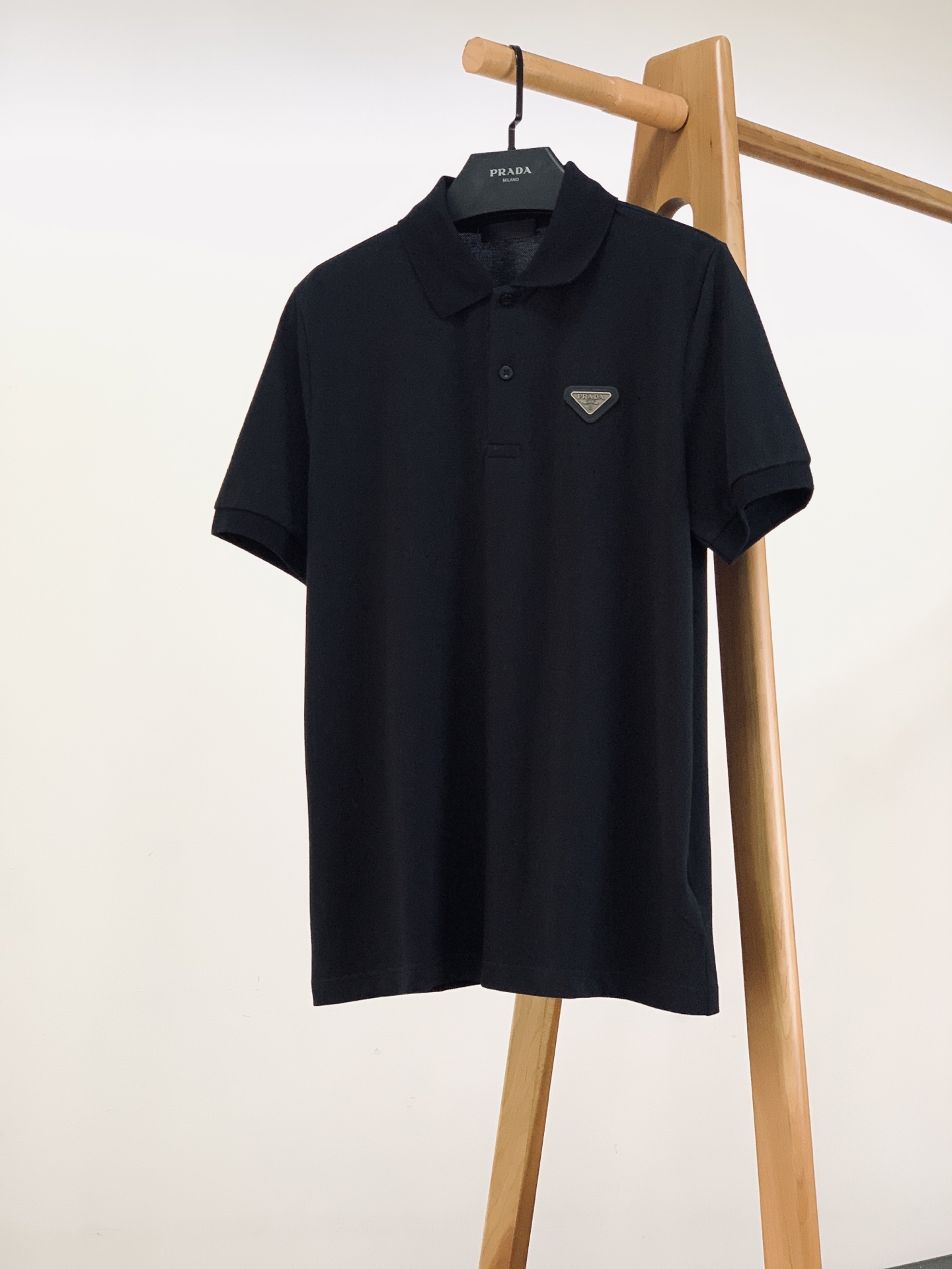 NO:841892,Prada 2026SS new product in spring and summer, classic triangle logo Polo shirt. Customized high-count piqué cotton fabric, with built-in three-dimensional breathable mesh, excellent moisture absorption and perspiration, you can wear it all day long in summer without sweating!  The fabric has been pre-shrunk and shaped, so it won’t deform or pill after being washed for a long time. The upper body is crisp and stylish but not soft, and the soft touch is super comfortable when worn next to the body. The classic lapel + placket engraved button design is neat and not stiff. The metal triangle mark on the left chest is the finishing touch. It is low-key and dignified, and the details are full. The slightly loose tailoring does not flatter the figure, and is available in black/white/navy blue. It is a must-have item for casual business. ……………………………………………………  SizeS-XL,,prada,prada,19860909Prada 普拉达 2026SS春夏新品 经典三角标Polo衫. 定制高支珠地棉面料,自带立体透气网眼,吸湿排汗超优秀,夏天穿一整天都清爽不闷汗！面料做了预缩定型处理,久洗不变形不起球,上身挺括有型不软塌,软乎乎的触感贴身穿也超舒服. 经典翻领+门襟刻字纽扣设计,利落不呆板,左胸金属三角标是点睛之笔,低调又显贵,细节感直接拉满.微宽松剪裁不挑身材,黑/白/藏青三色可选,休闲商务必备单品. …………………………………………………… SizeS-XL,,prada,prada,,Men's clothing