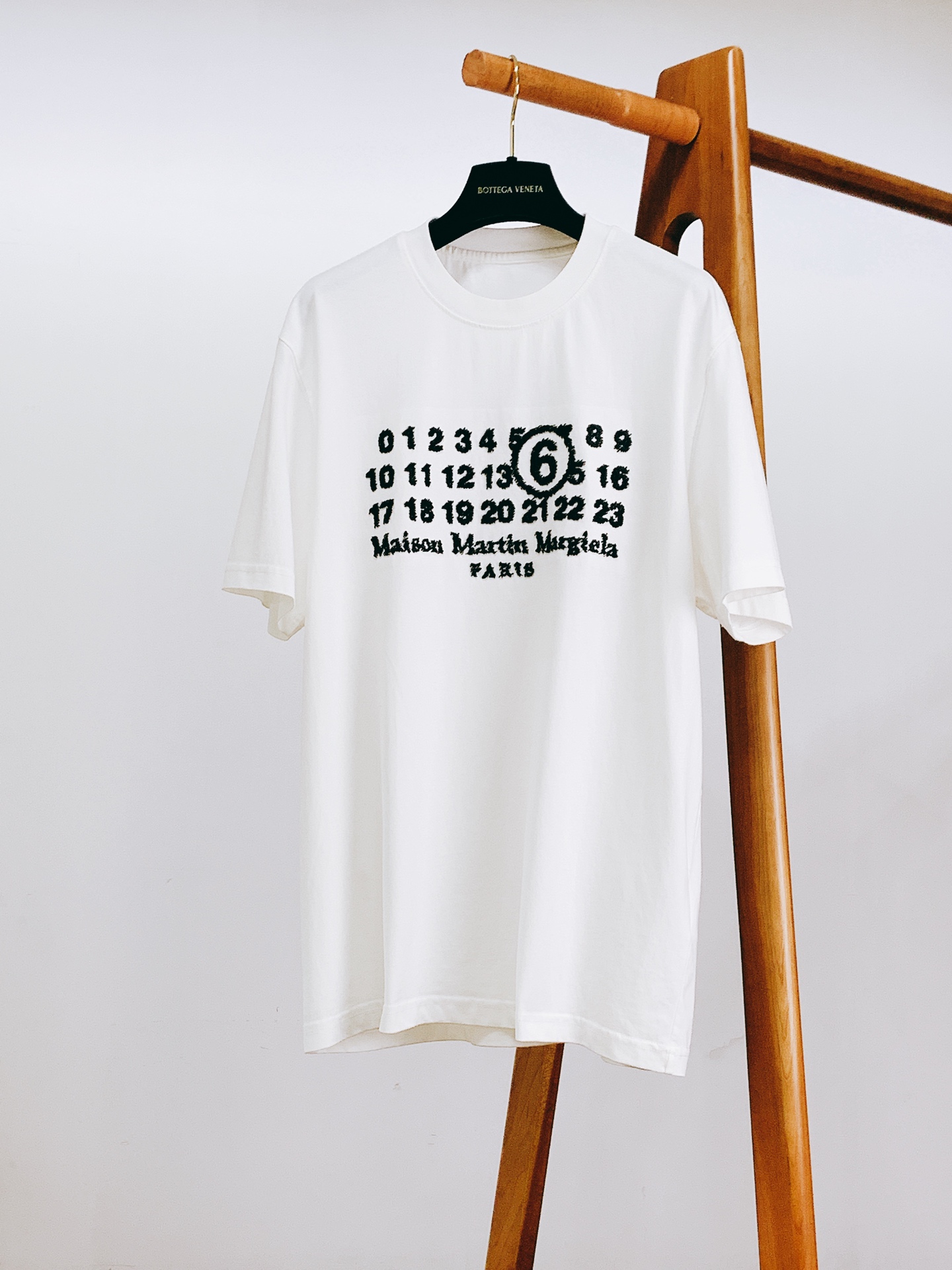 NO:841898,Maison Margiela MM6 2026SS new product in spring and summer, digital series raw edge embroidered T-shirt. Customized high-count double-strand combed cotton fabric, soft and skin-friendly, with a smooth drape. The fabric has been pre-shrunk and anti-pilling, so it will not deform or pill after long-term washing. It has excellent moisture absorption and perspiration, so you can wear it all day long in summer without sweating.  Classic round neck + double-strand ribbed hem, the neckline is not easy to curl and deform after long-term wear. The number series and brand name embroidery on the chest are made with hand-made raw edge embroidery technology. The lines are rough and casual, restoring the brand's deconstructive aesthetics, low-key and noble. The slightly loose cut is not flattering on the body shape, and is available in black/white. It is a versatile style in the summer wardrobe, close your eyes and avoid stepping on thunder!  …………………………………………………… SizeM-5XL,, masion margiela, masion margiela, tees, t-shirt,19860909Maison Margiela MM6 马丁马吉拉 2026SS春夏新品 数字系列毛边刺绣T恤. 定制高支双股精梳棉面料,触感软糯亲肤,自带柔滑垂坠感.面料做了预缩定型与抗起球处理,久洗不变形不起球,吸湿排汗超优秀,夏天穿一整天都清爽不闷汗. 经典圆领+双股线罗纹锁边,领口久穿不易卷边变形,胸前的数字系列与品牌名称刺绣采用手工感毛边绣工艺,线条毛糙随性,还原品牌解构主义美学,低调又显贵.微宽松剪裁不挑身材,黑/白两色可选,夏日衣柜里的百搭神款,闭眼入不踩雷！ …………………………………………………… SizeM-5XL,,masion margiela,masion margiela,tees，t-shirt,,Men's clothing